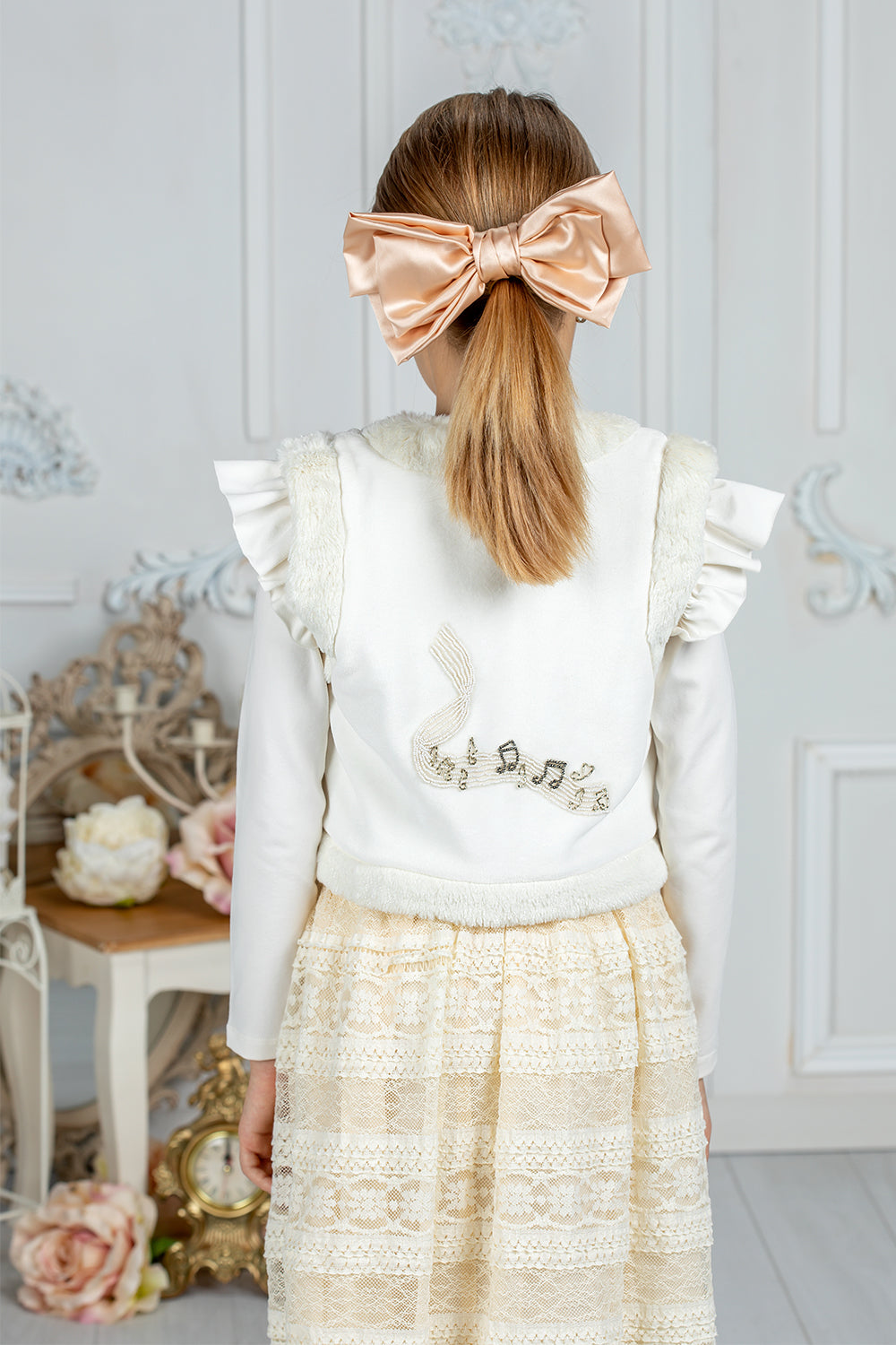 White faux fur vest with musical embroidery