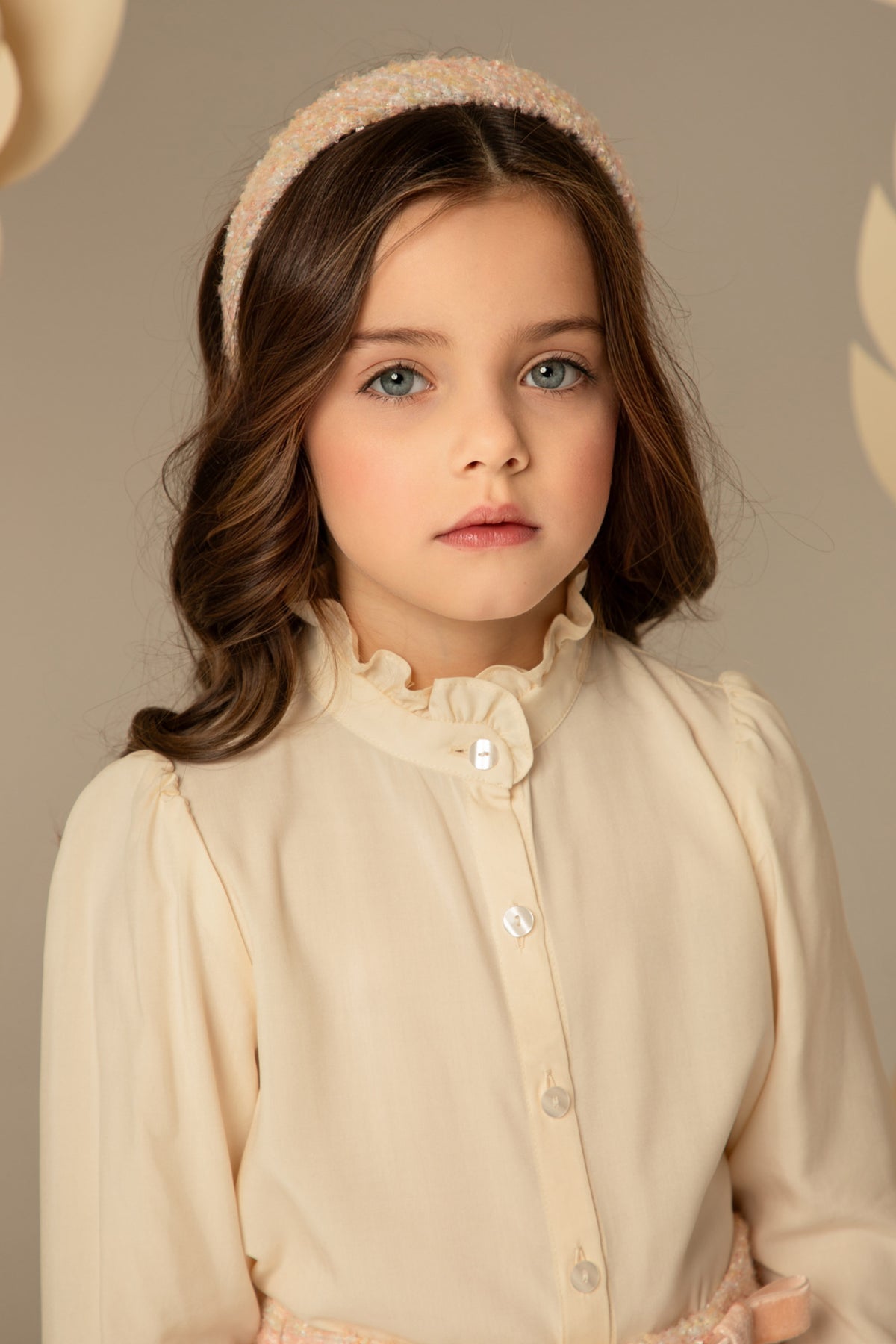 Close view of the ruffled collar and pearl buttons