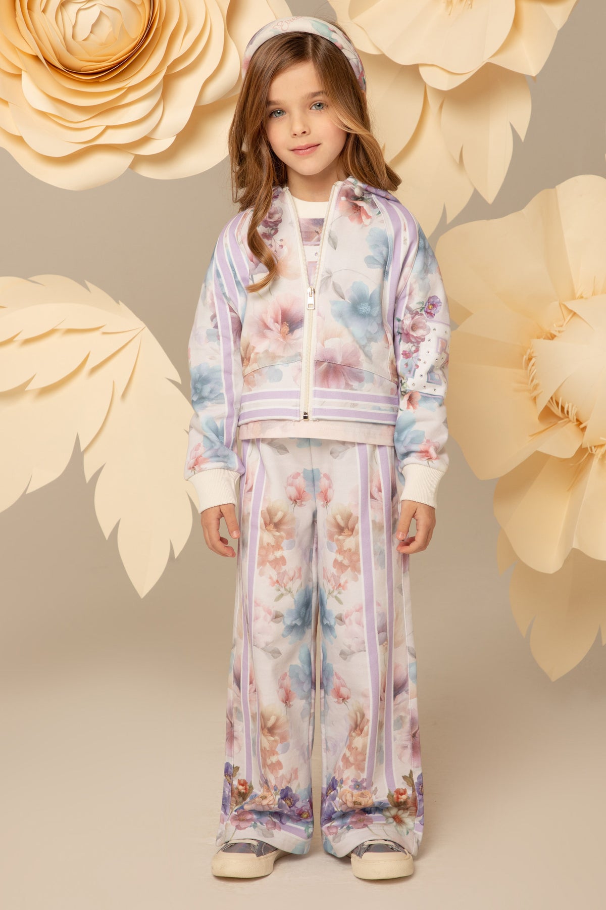 Girl wearing a pastel floral zip hoodie and wide-leg trousers