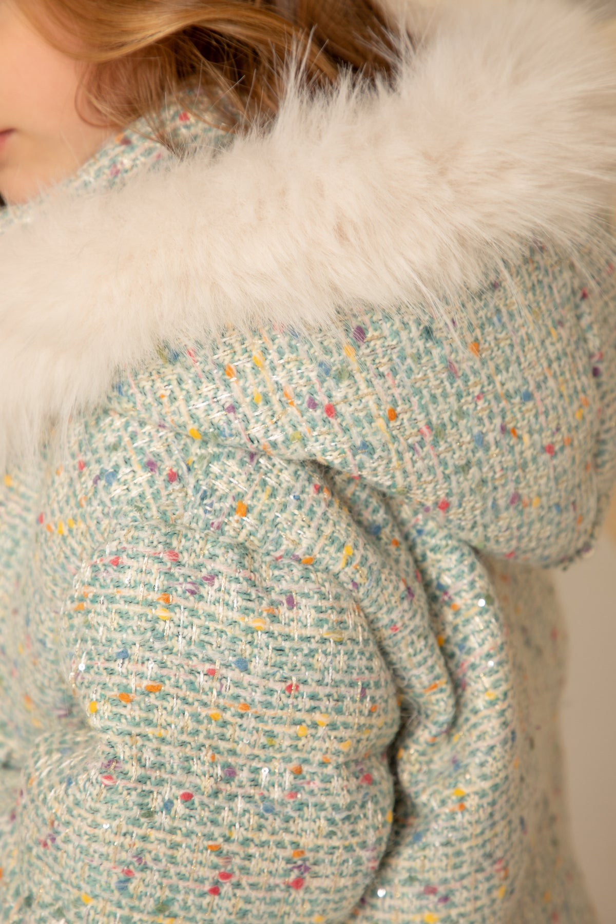 Close view of the tweed and fur-trimmed hood