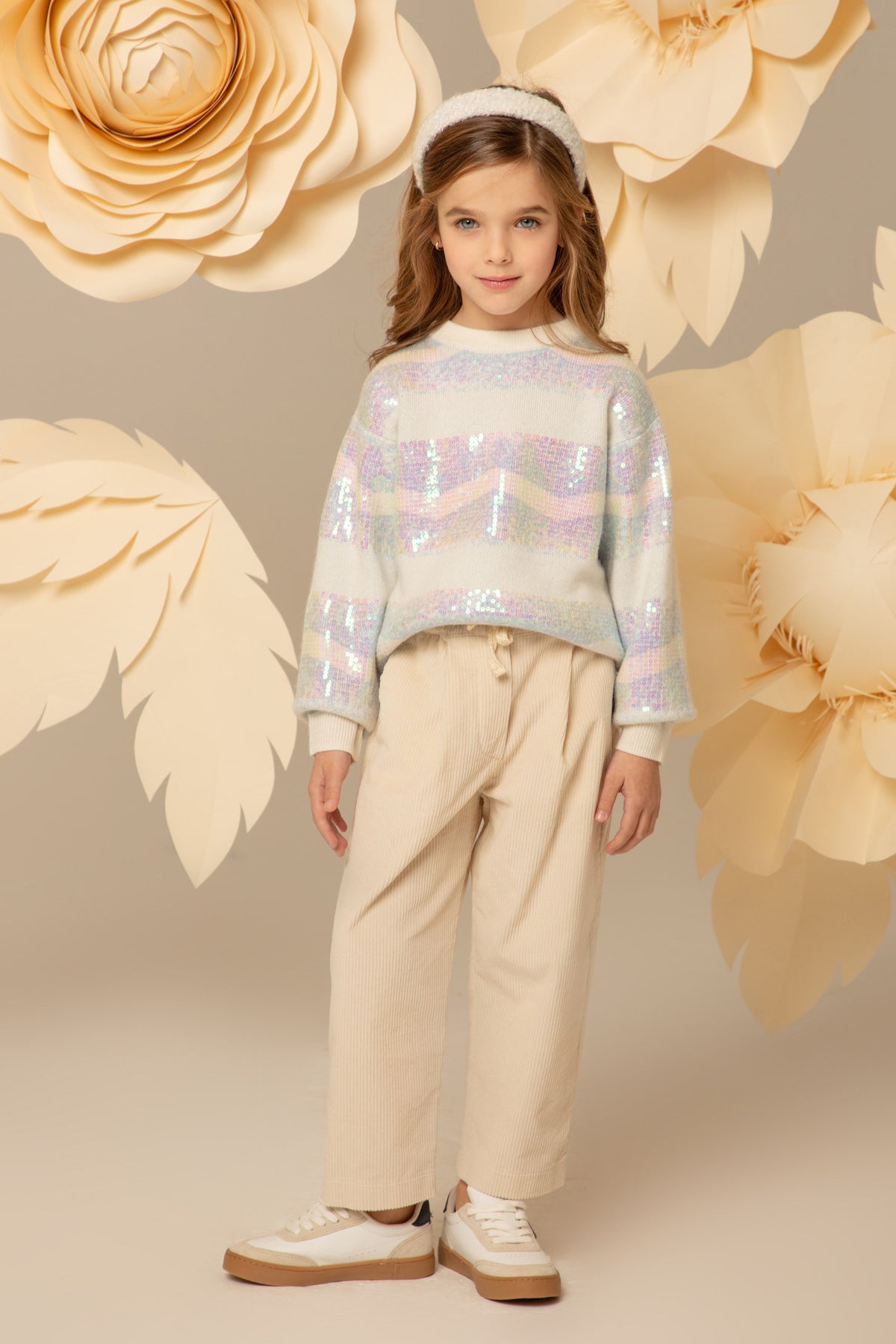Girl wearing an oversized pastel striped sequin sweater