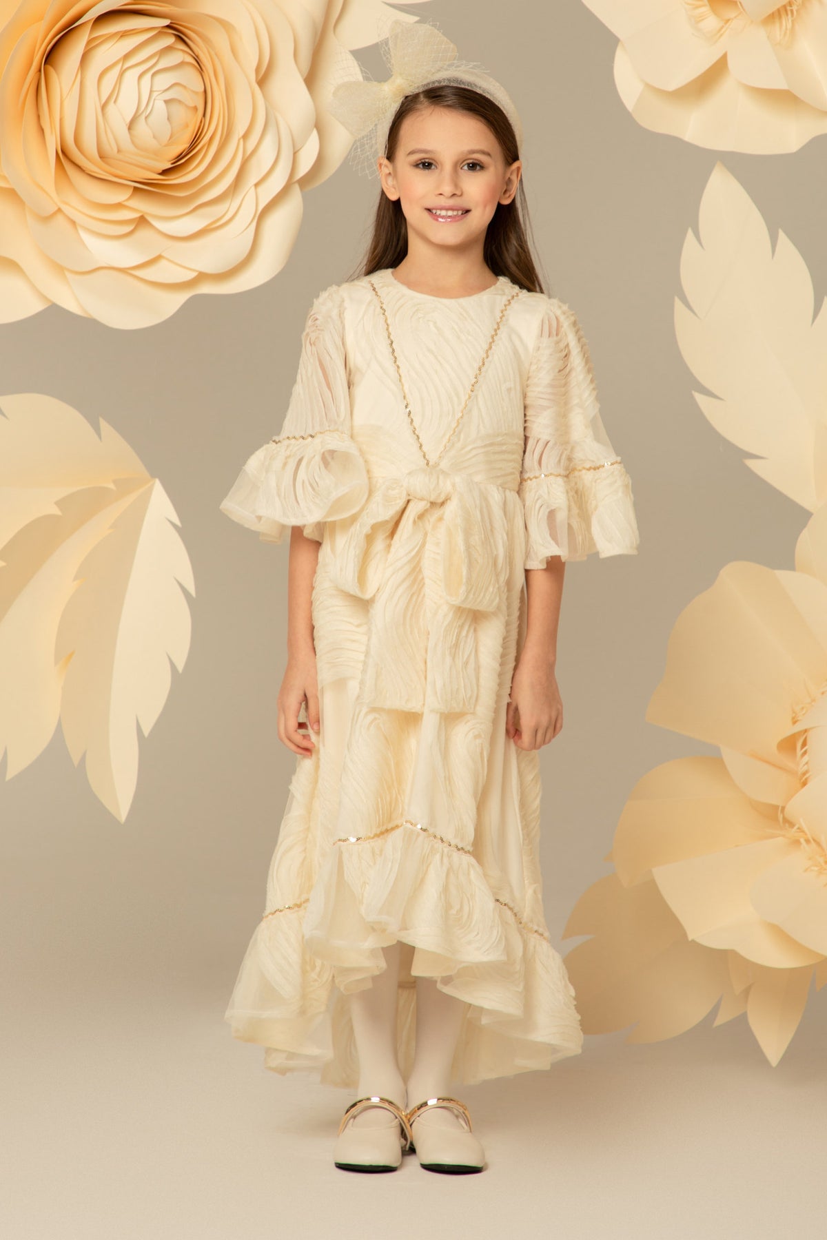 Girl wearing a long ivory chiffon dress with gold sequins