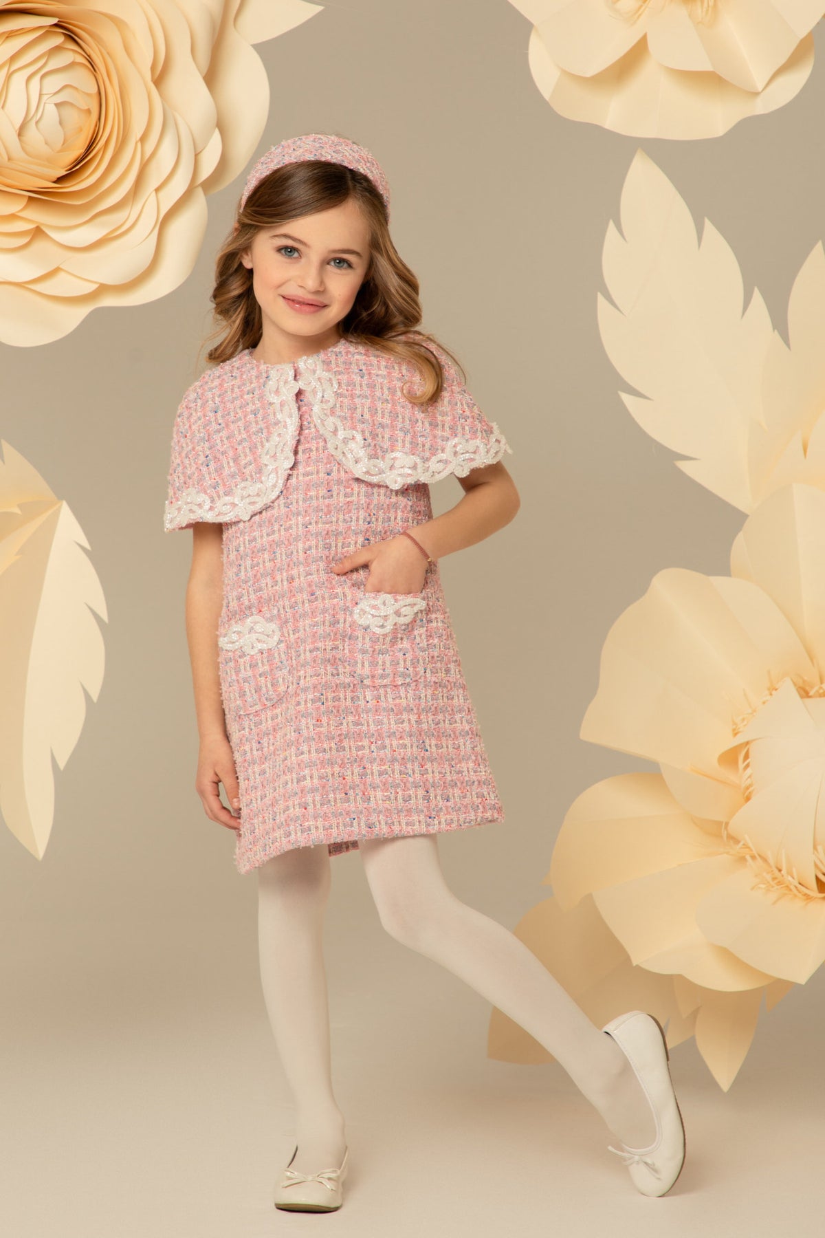 Girl wearing a pink tweed dress with a beaded lace cape collar