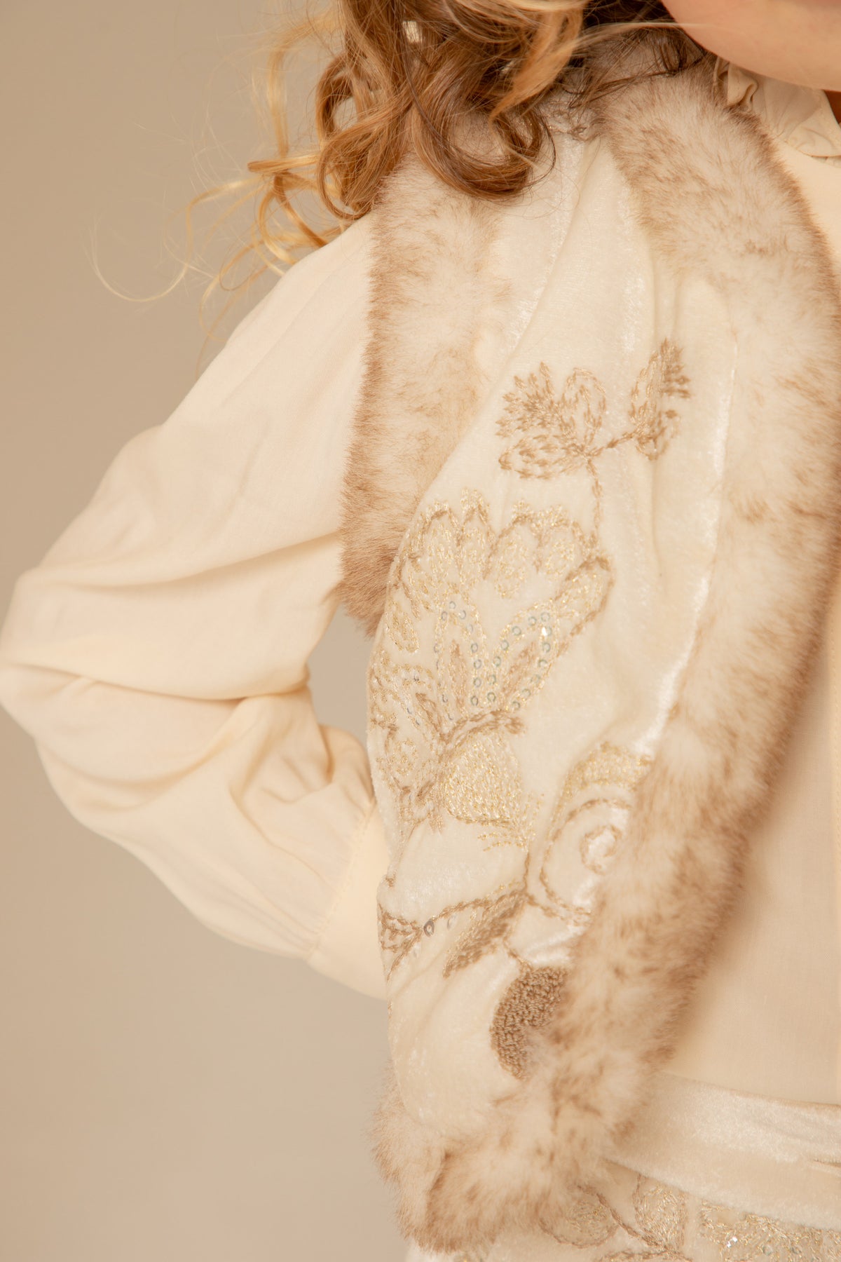 Back view of an ivory velvet padded vest