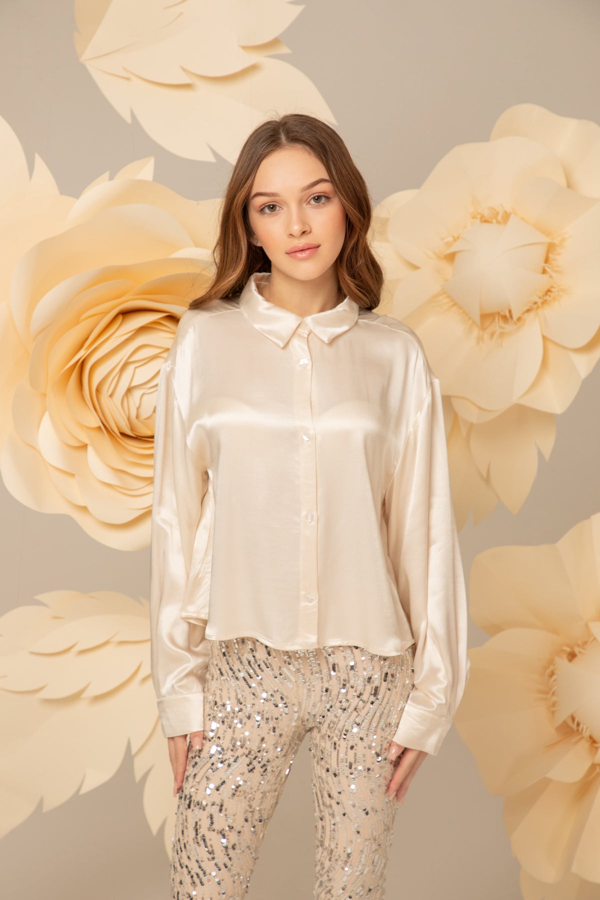 Silver sequin flared trousers worn with an ivory shirt