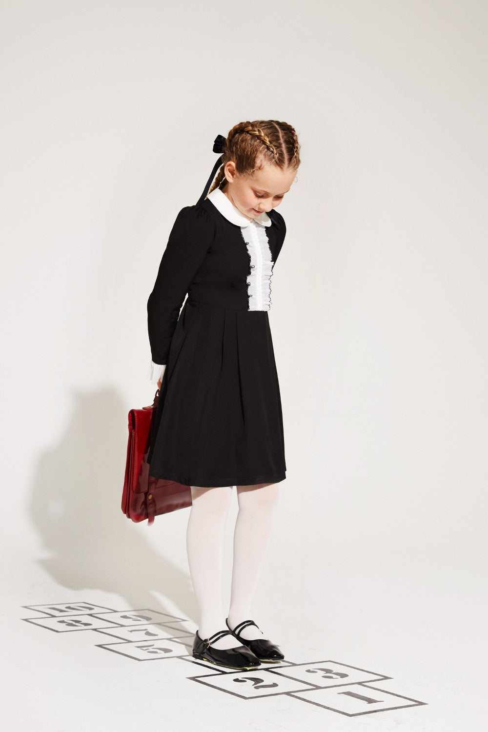 Black dress with white collar and pleated front detail