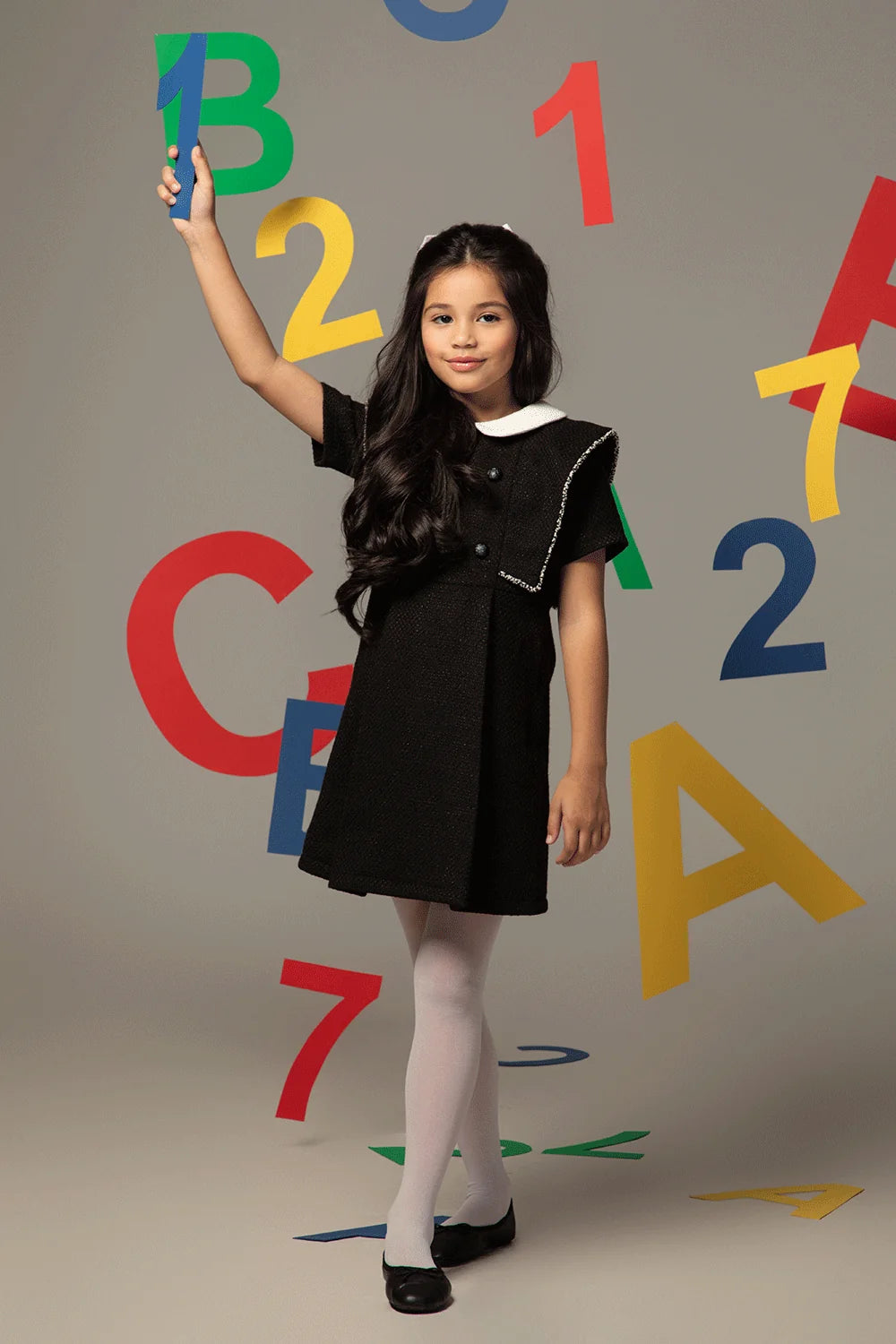 Black tweed dress with white collar, double-breasted fastening and cape-style shoulders