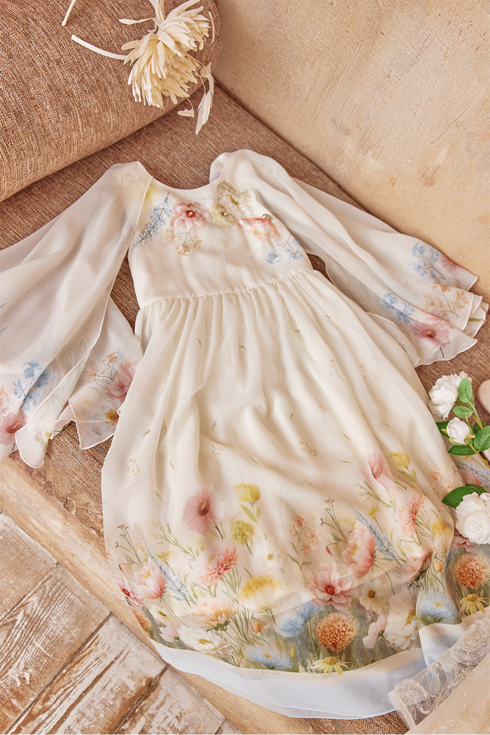 White chiffon dress with floral print, flowing sleeves and delicate hand-embelishement