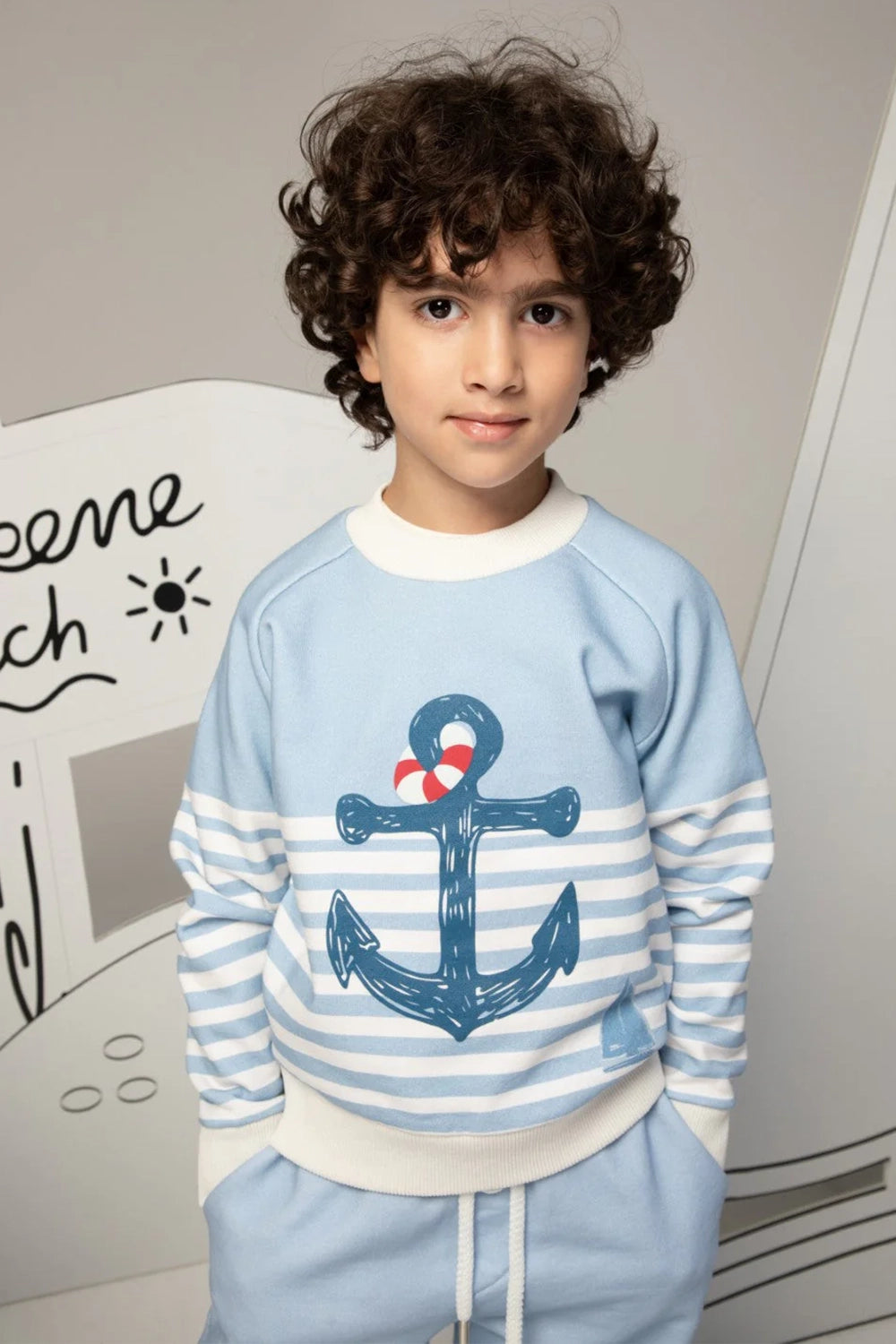 Light blue pants with white striped cuffs and a small sailboat print motif on the leg