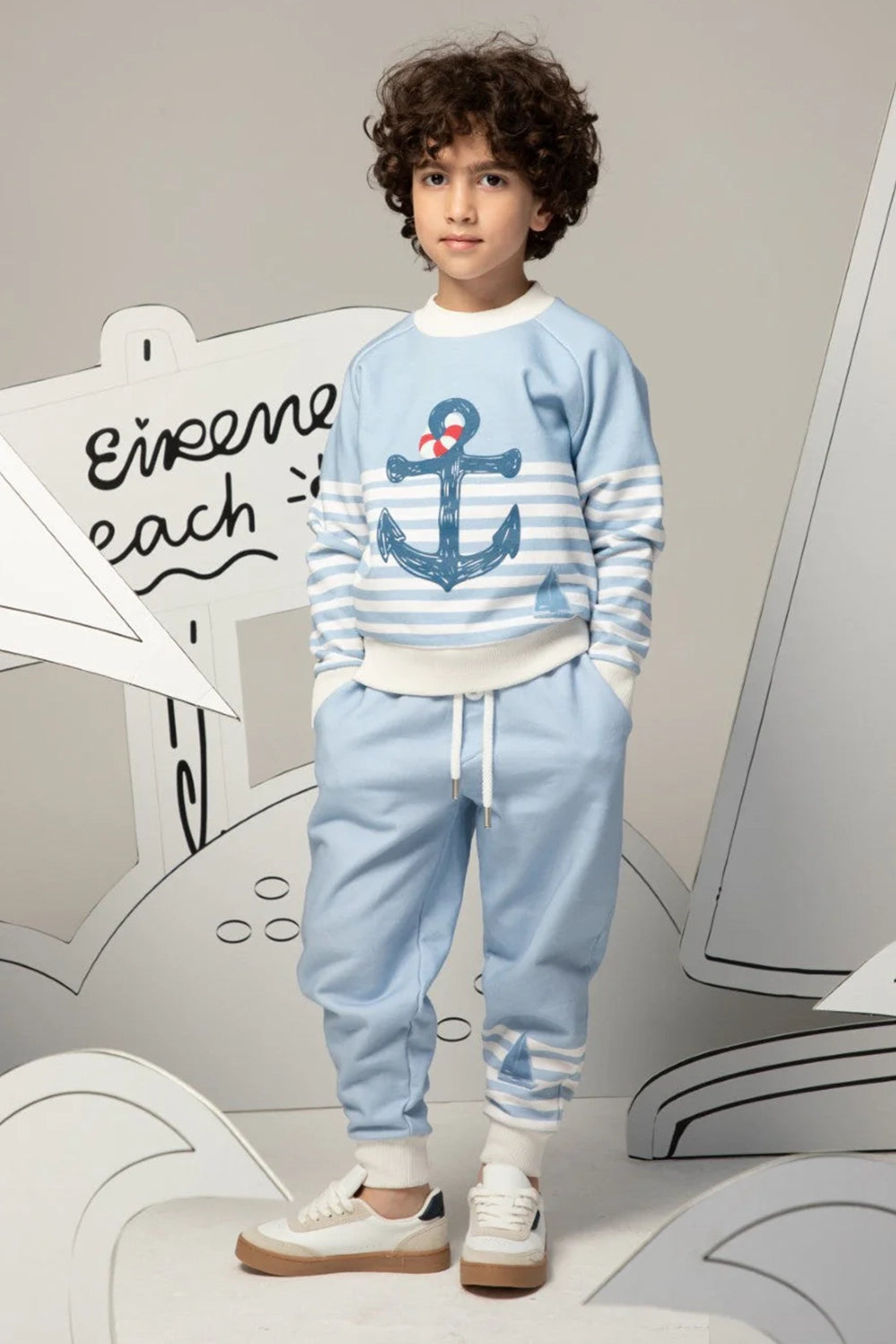 Light blue pants with white striped cuffs and a small sailboat print motif on the leg