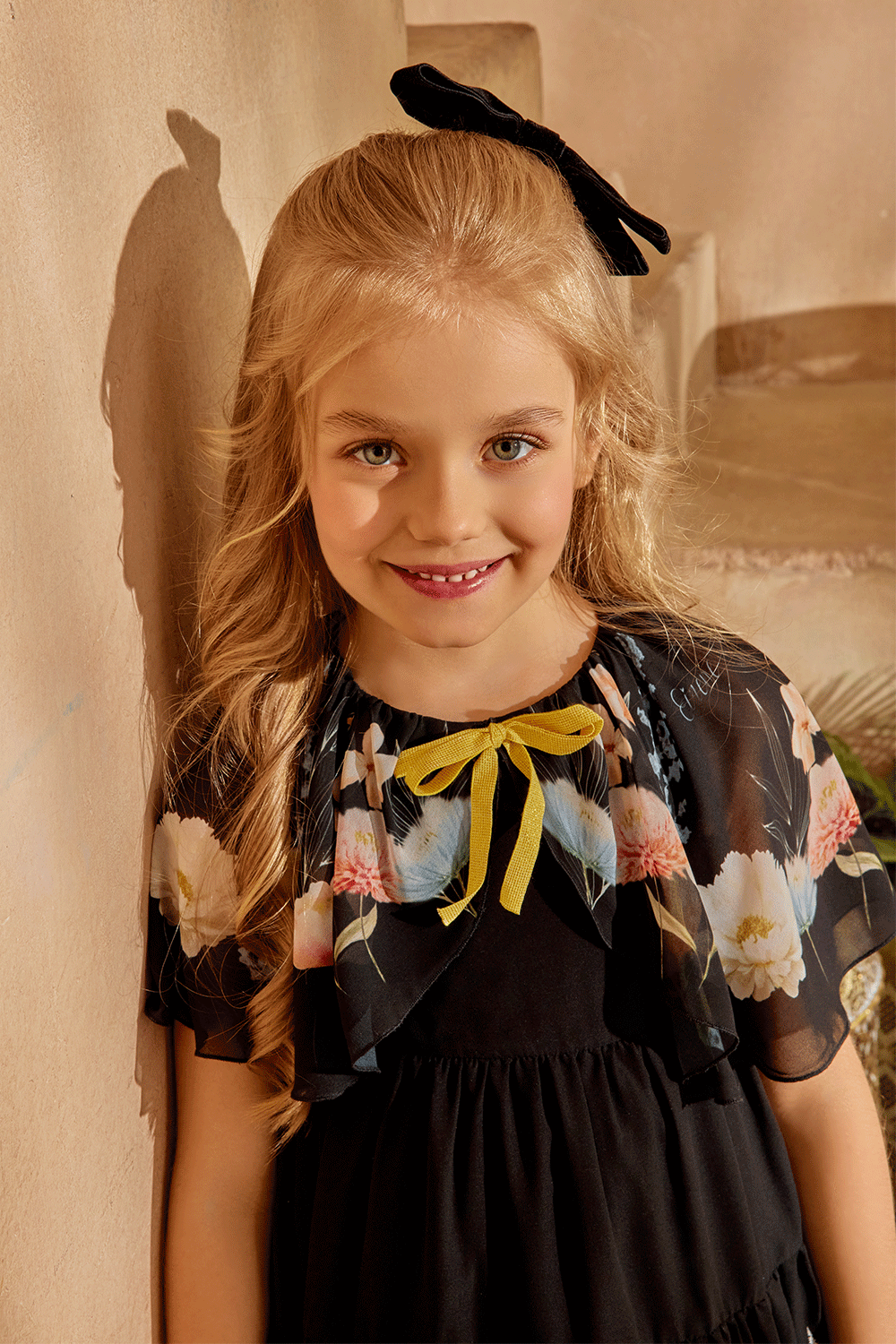 Black chiffon dress with floral cape and yellow bow detail