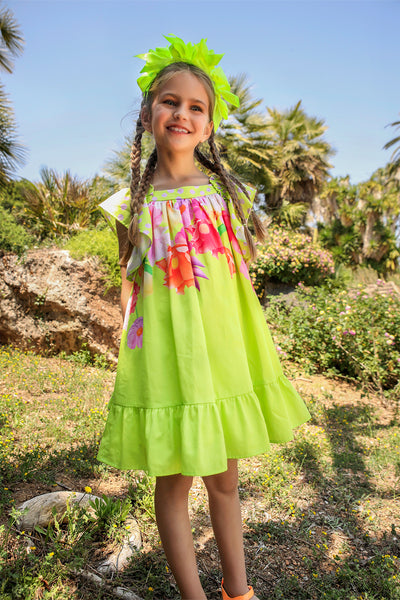 Neon green dress with bright flowers print and a bow on the back