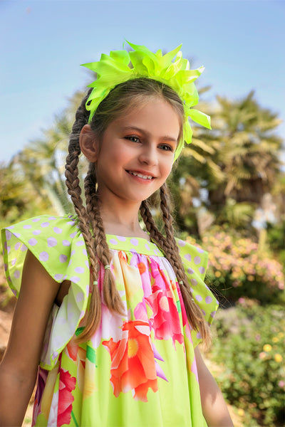 Neon green dress with bright flowers print and a bow on the back