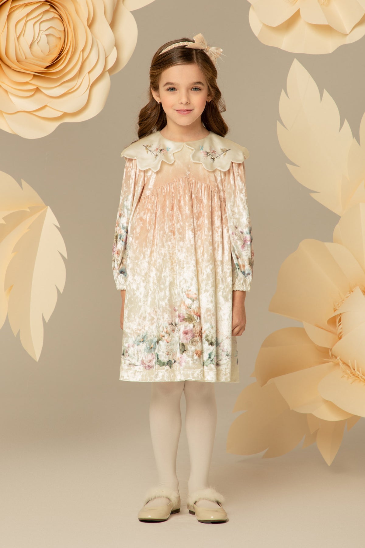 Girl wearing a peach velvet dress with a floral print