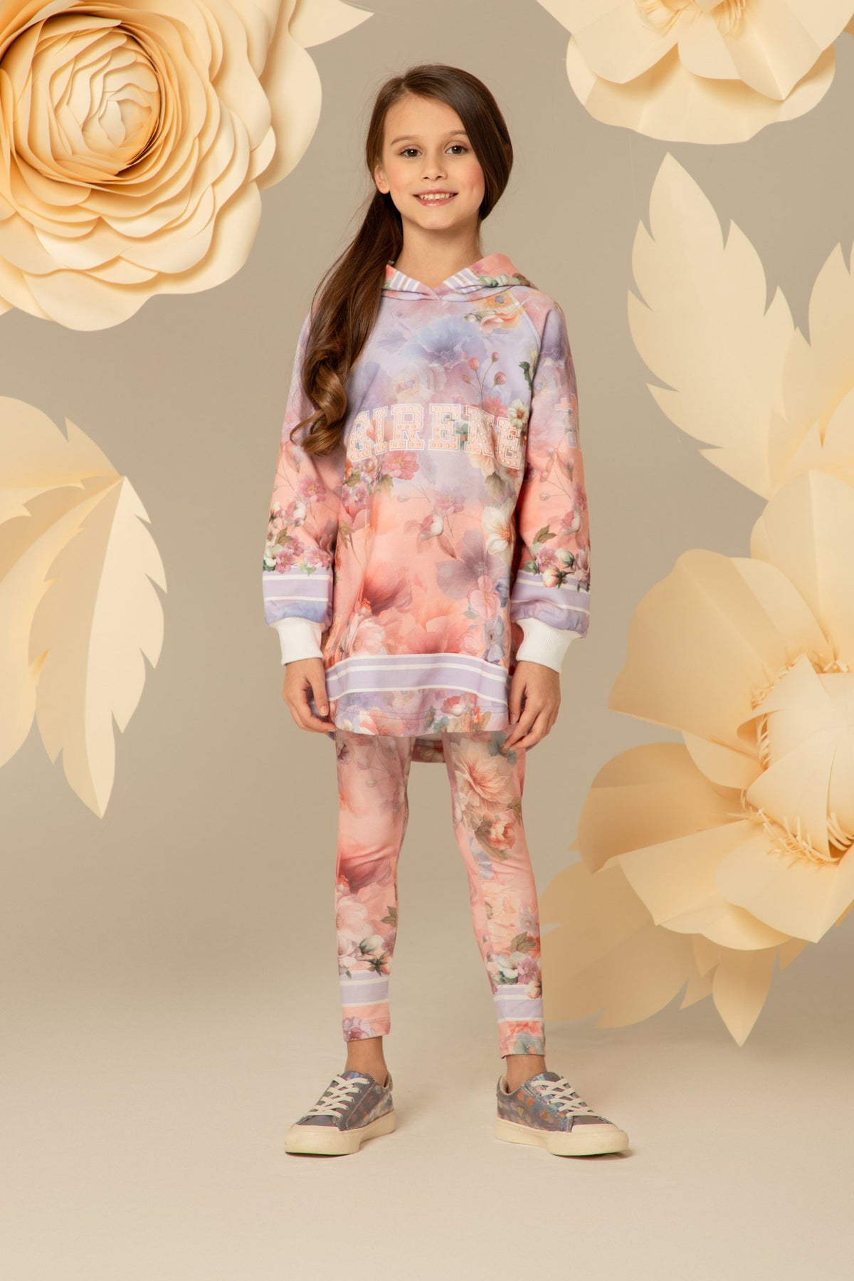 Girl wearing pastel floral leggings under a matching hoodie dress