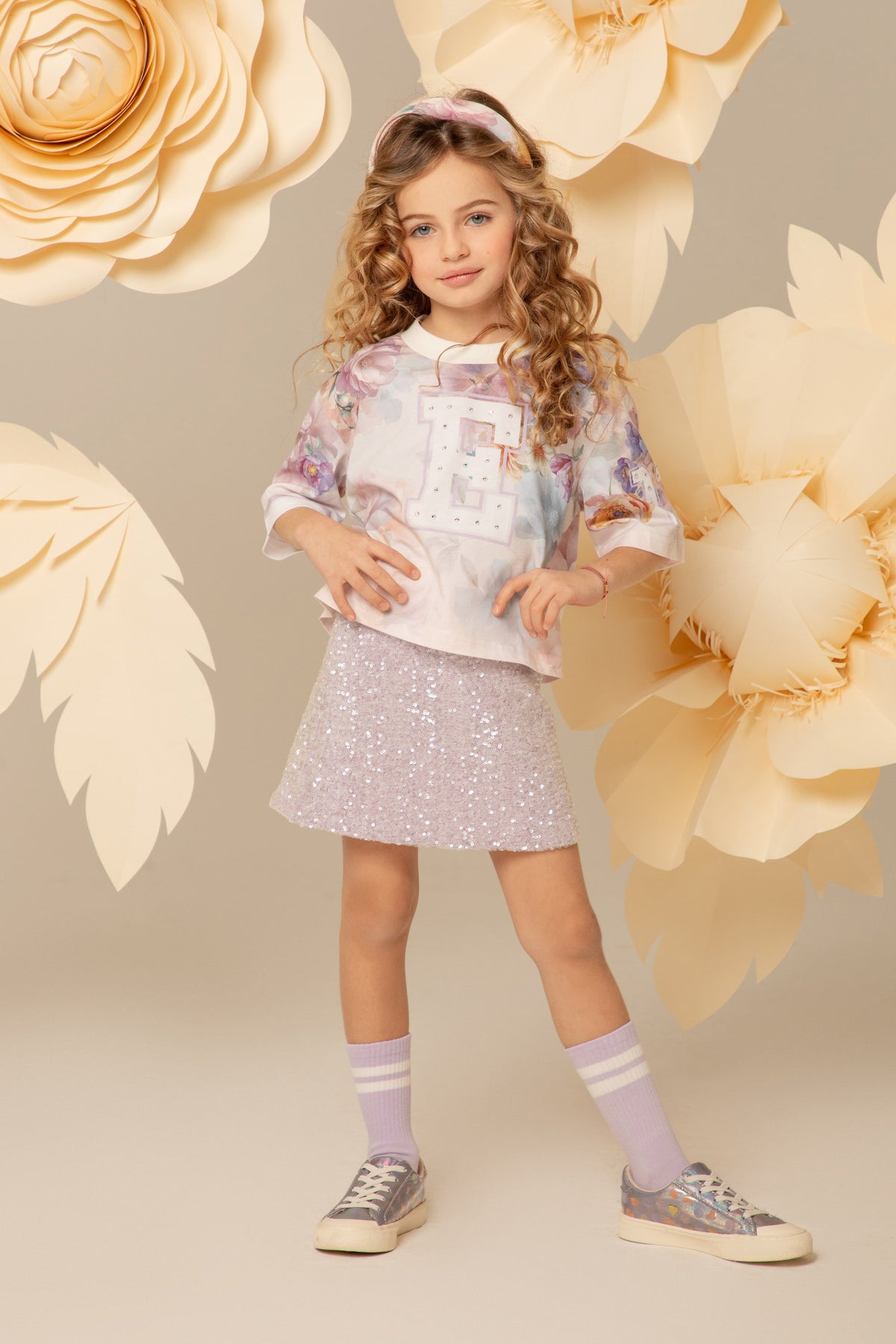 Girl wearing a boxy cotton t-shirt with a crystal E detail