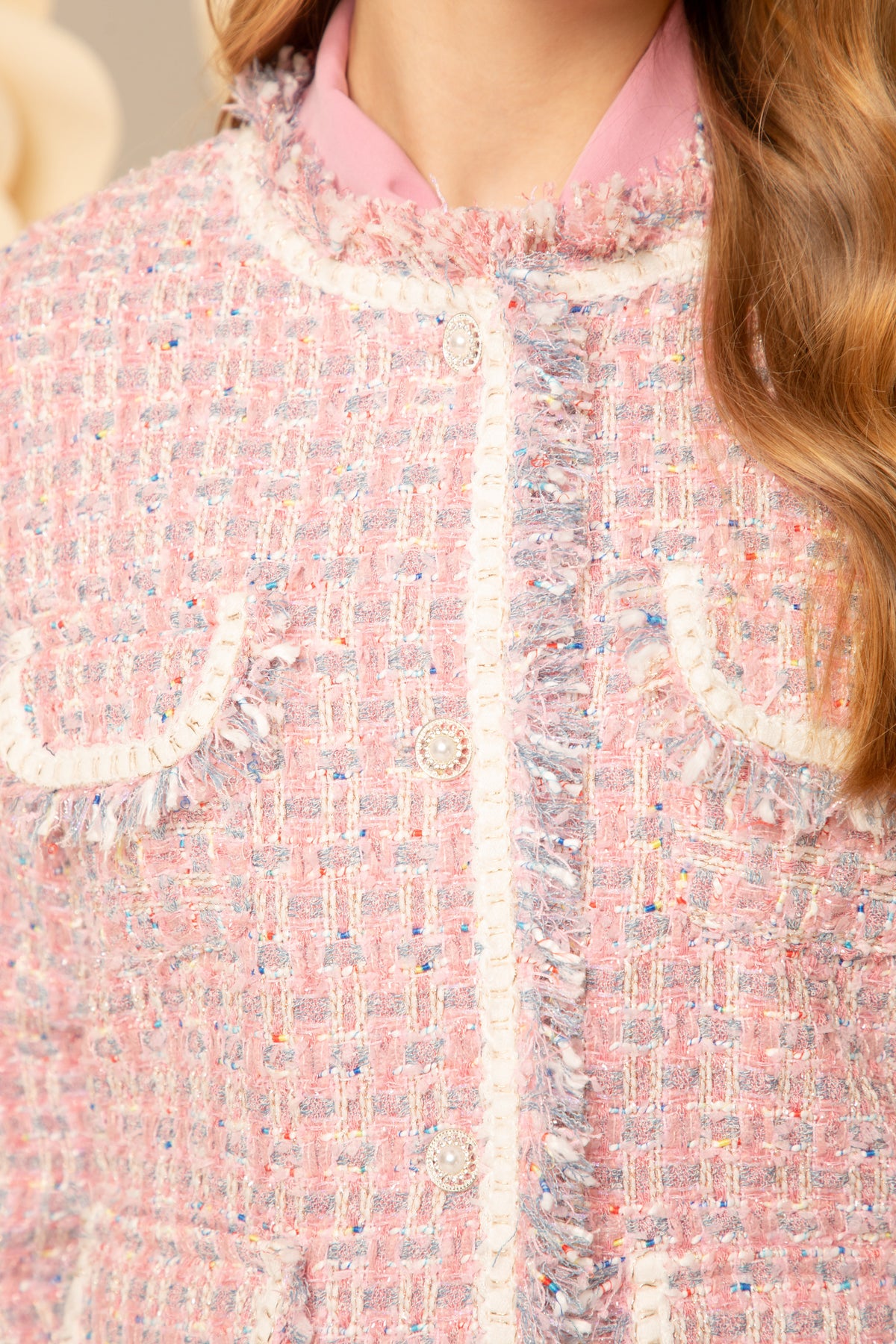 Close view of the gold buttons and fringed trim