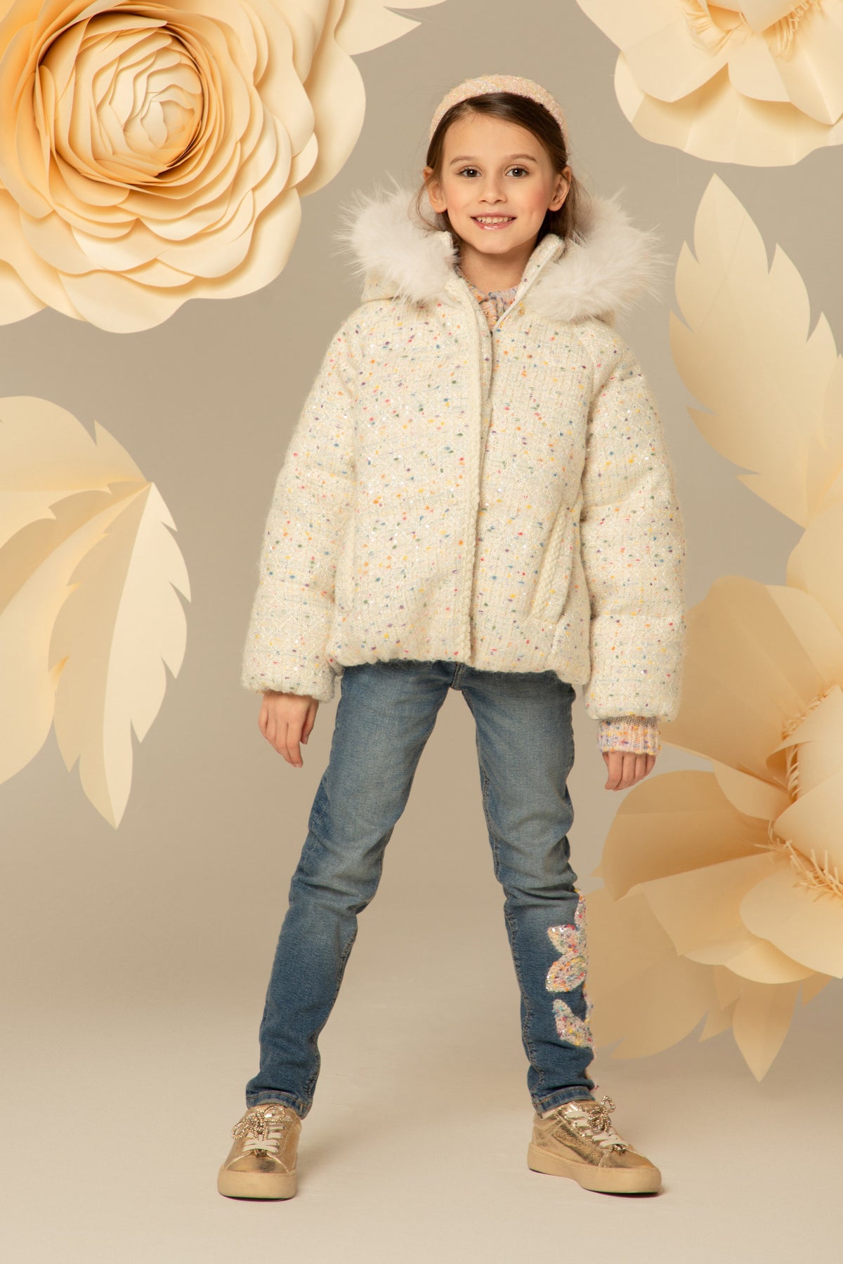 Girl wearing an ivory tweed down jacket with a fur-trimmed hood