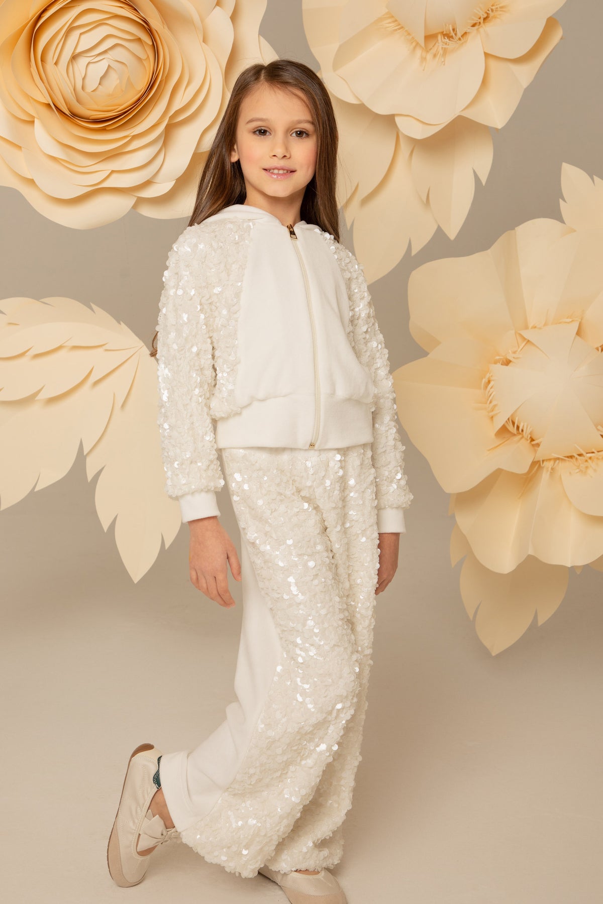 Girl wearing an ivory velvet set with zip hoodie and wide-leg trousers