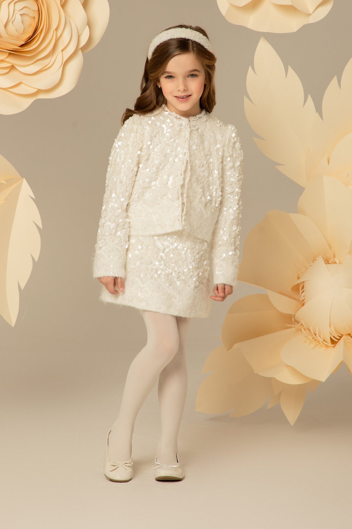Girl wearing a white sequin jacket and matching skirt