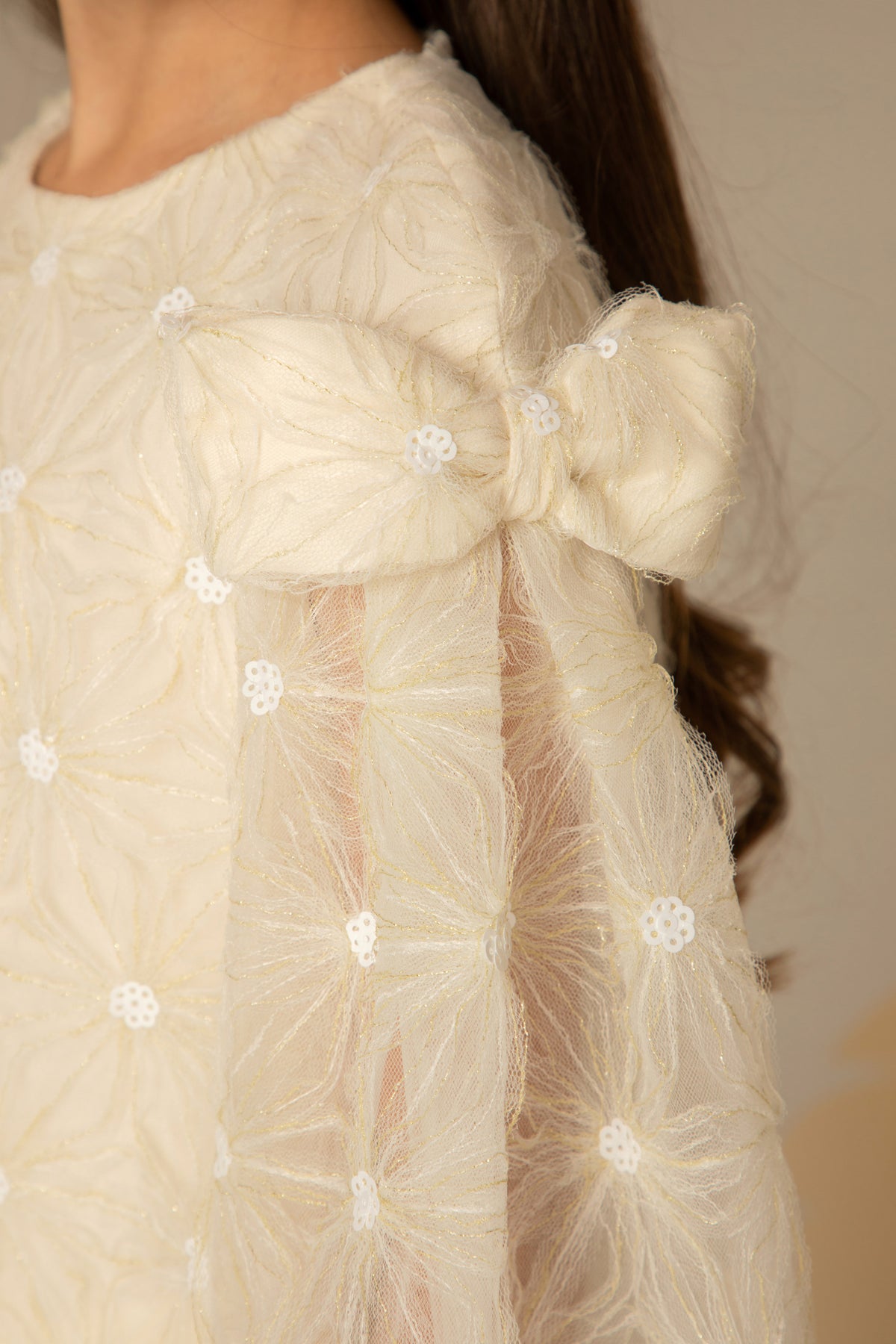 Close view of the shoulder bow and sequin lace