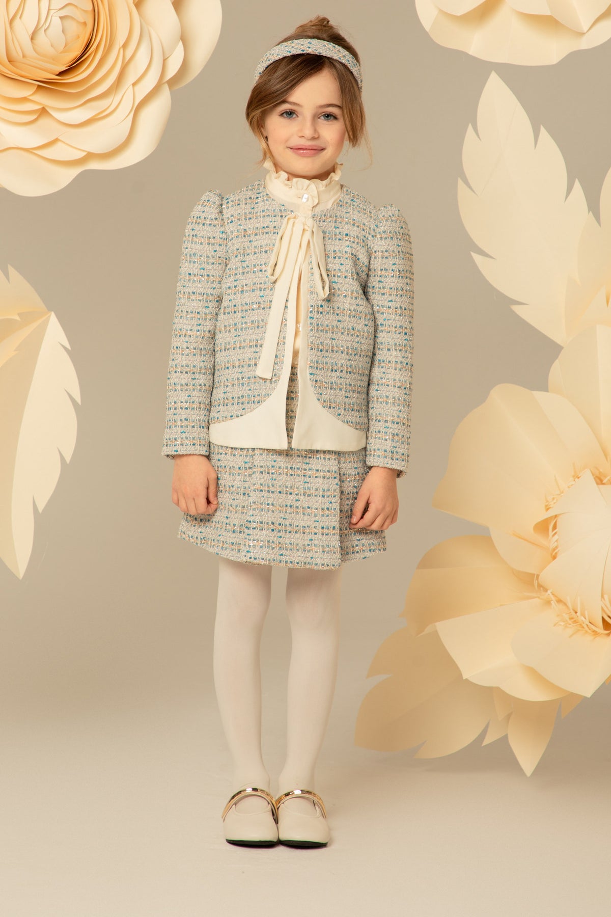 Girl wearing a blue and ivory tweed jacket and skirt set