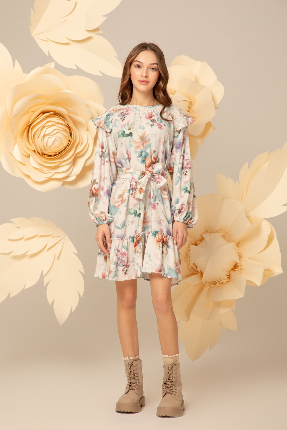 Girl wearing a pastel floral dress with a tie waist