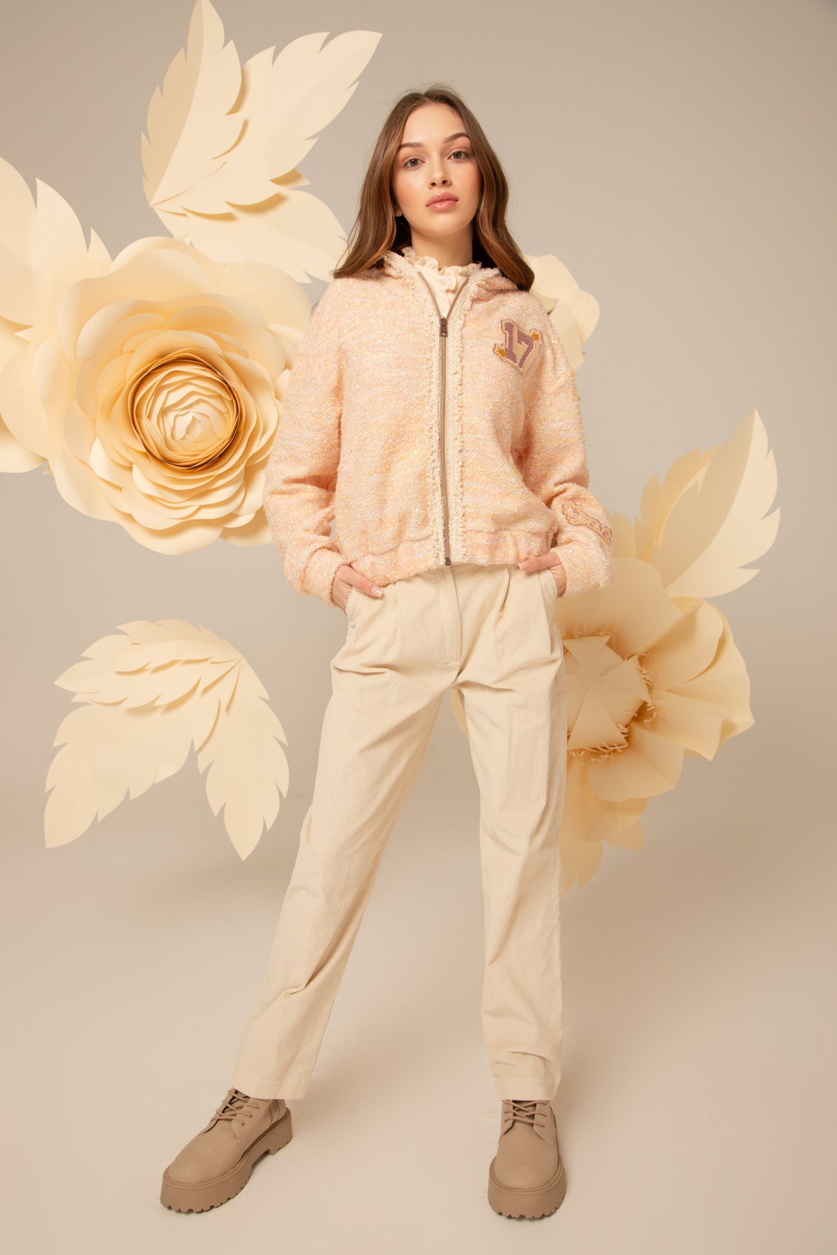 Girl wearing a peach tweed hoodie with a zip front