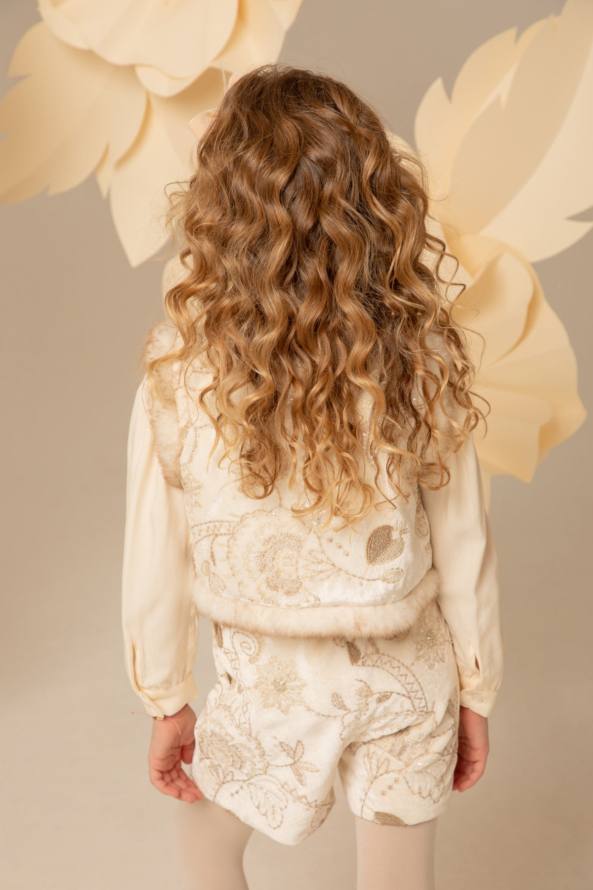 Detail of the faux fur trim on an ivory velvet vest