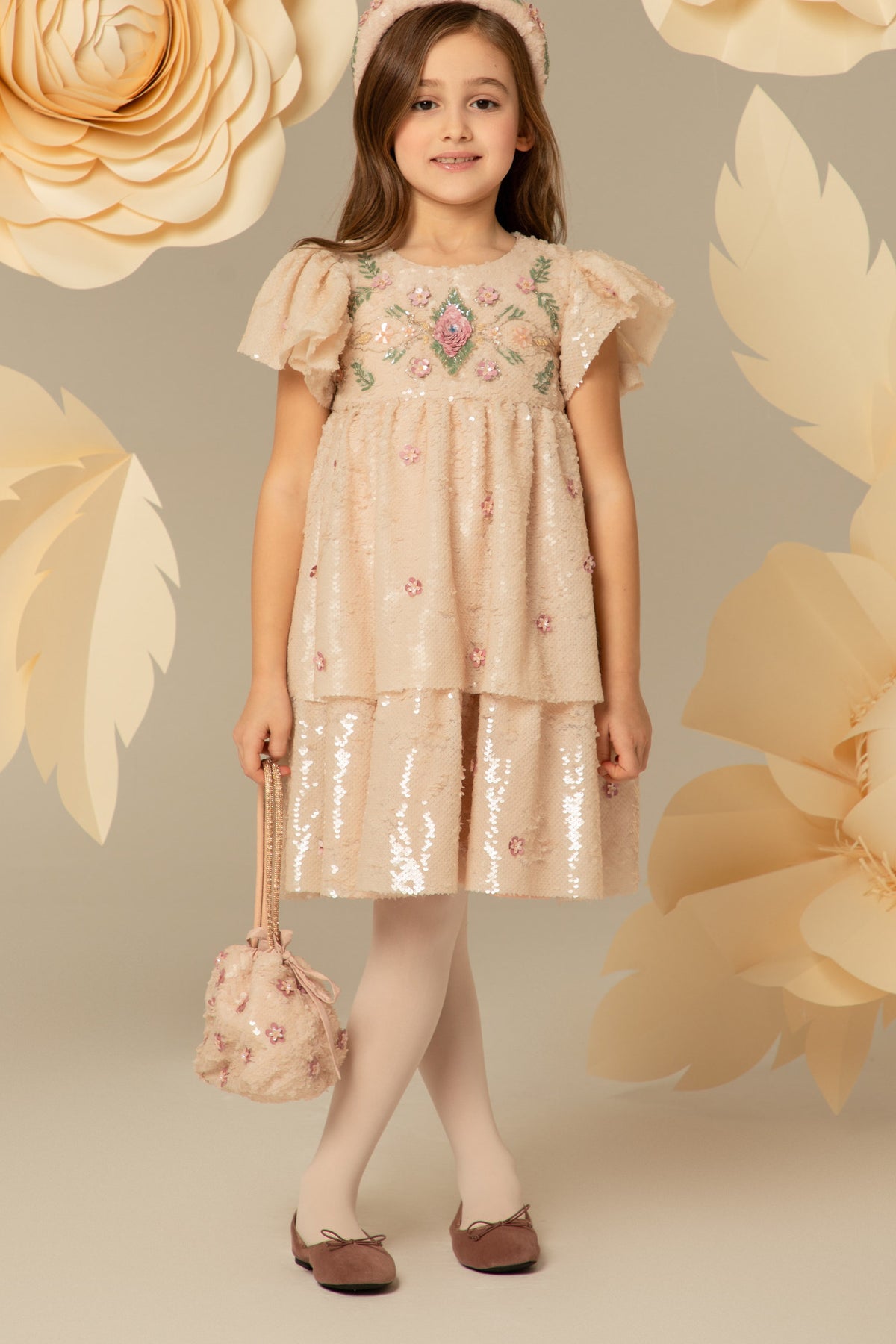 Girl wearing a dusty pink layered dress with 3D flowers