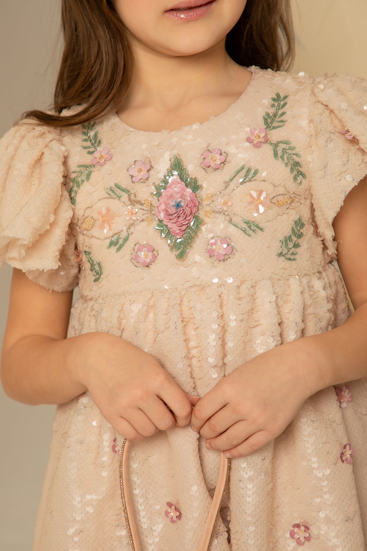 Close view of the hand-applied sequins and floral appliqués
