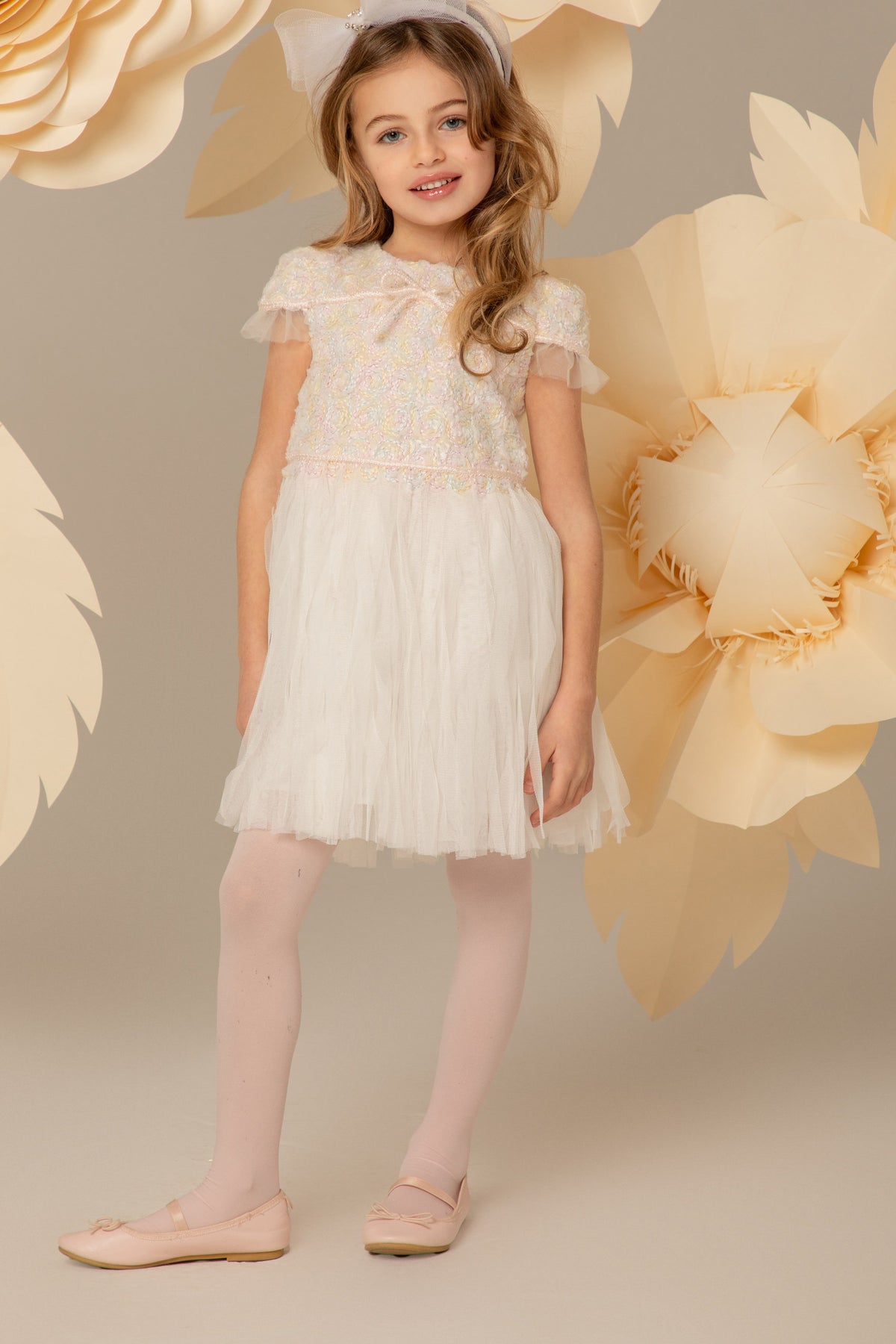 Girl wearing a white lace dress with a tulle skirt