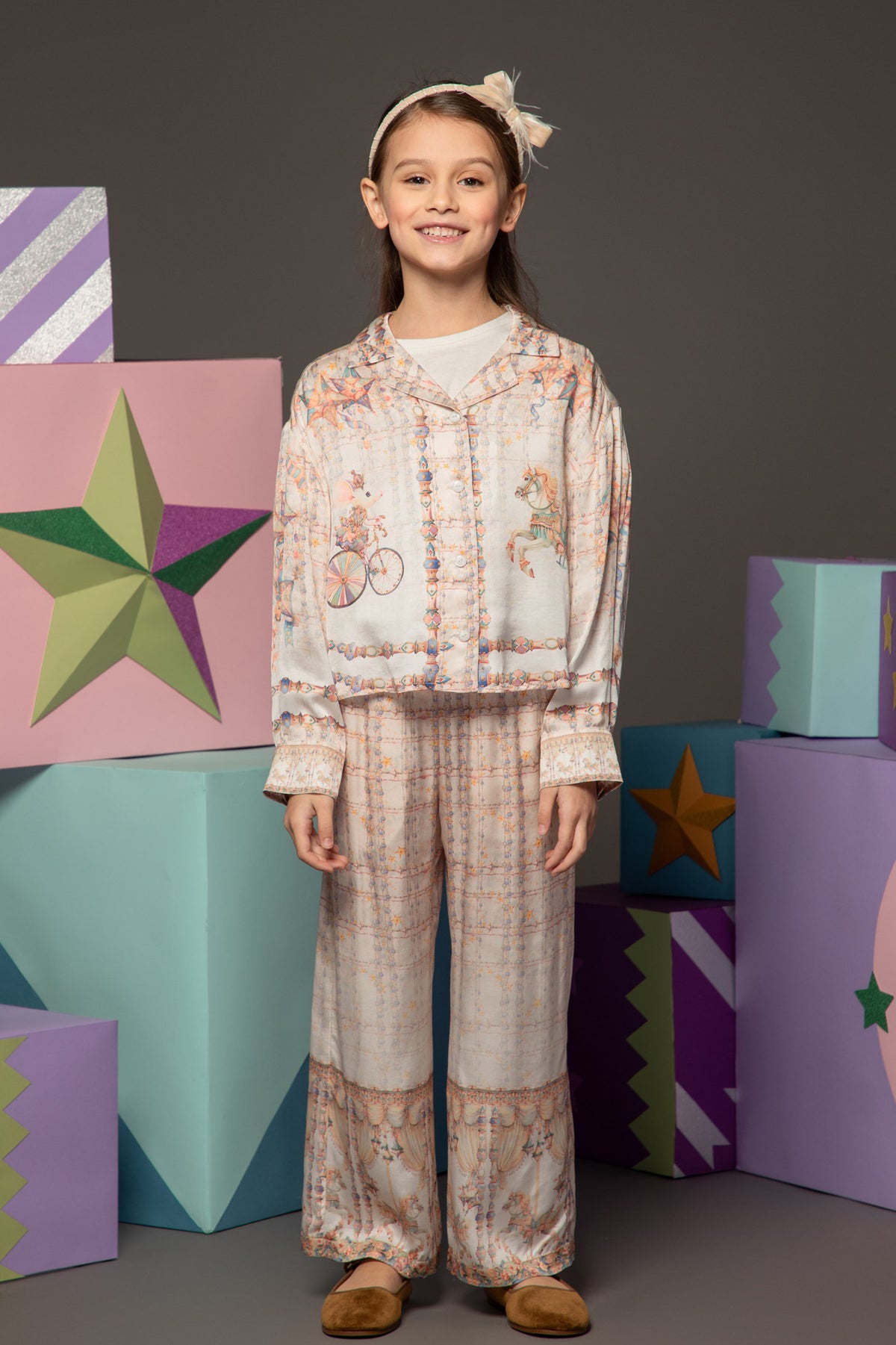 Girl wearing a silky two-piece set with carousel print