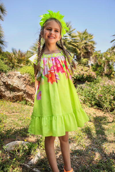Neon green dress with bright flowers print and a bow on the back