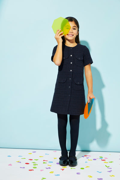 Young girl holding a green object against a light blue background