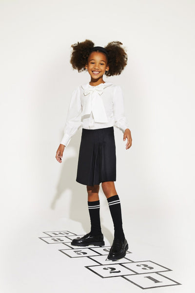 Black woven punto skirt for children, made with polyester, viscose, and elastane blend.