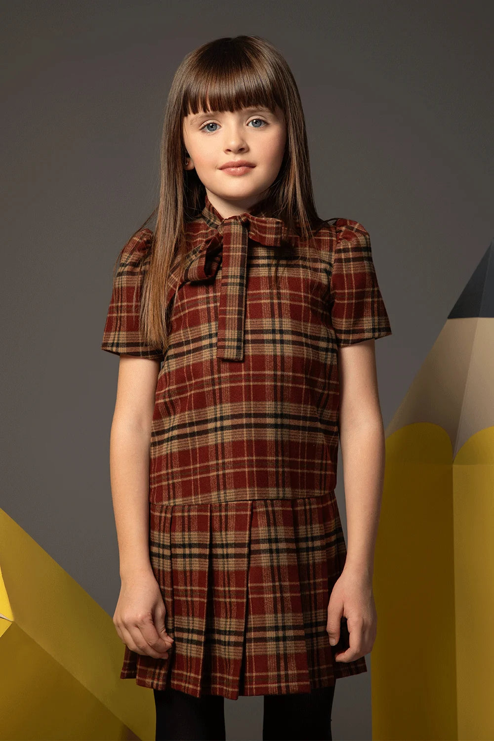 Beige and burgundy checked dress with short sleeves, bow collar and pleated skirt