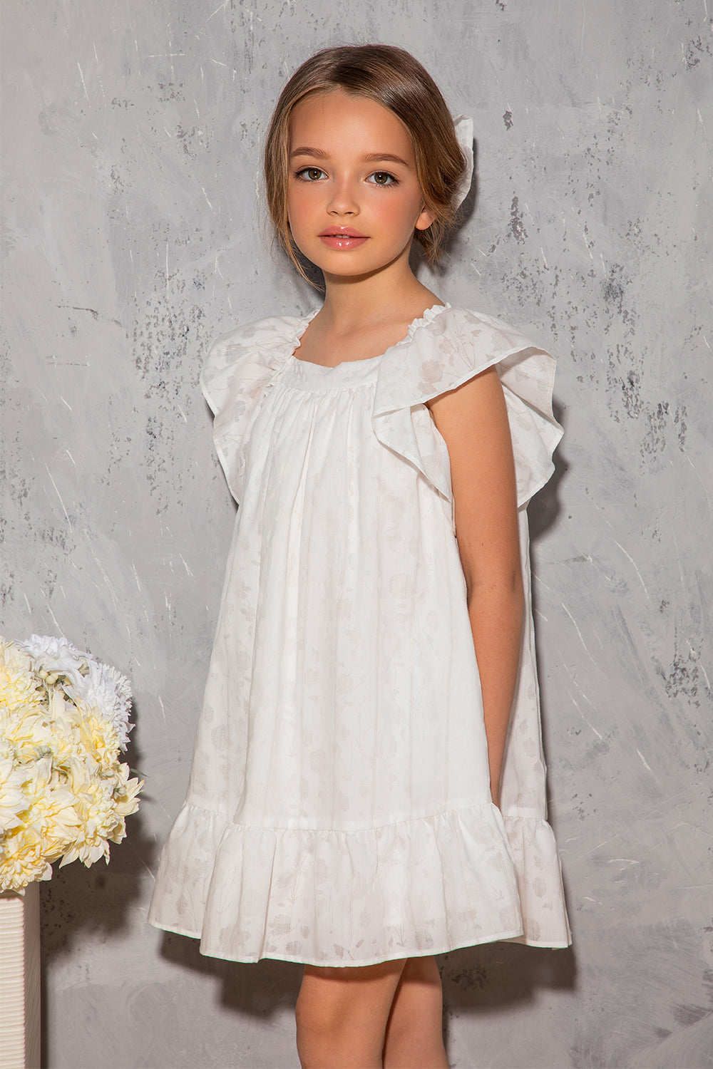 White flowy dress with dots, frills and big bow on the back