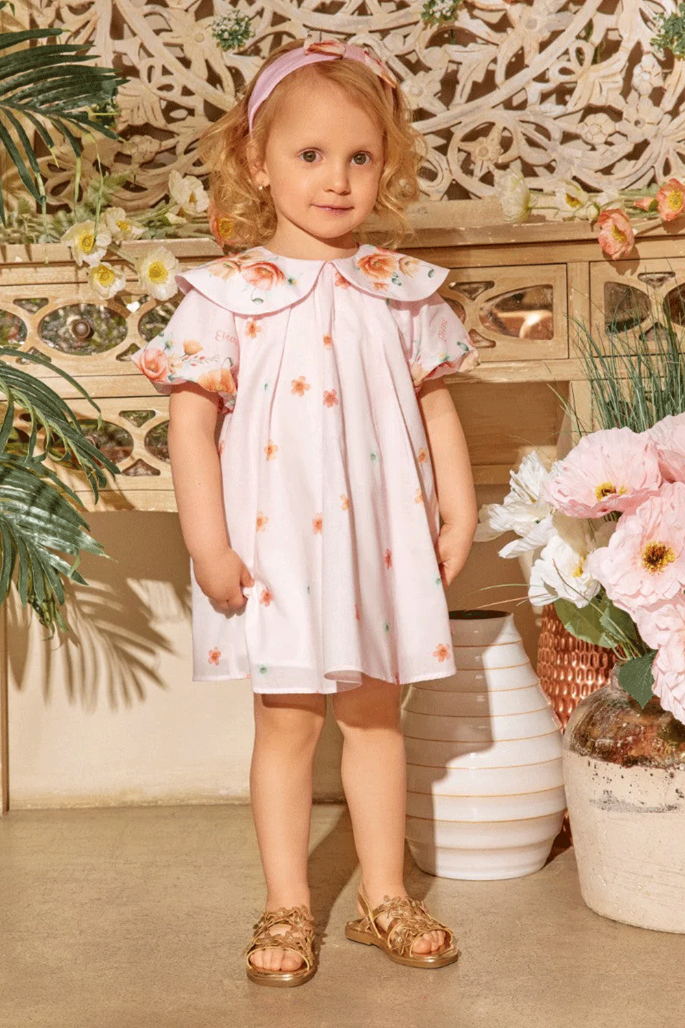 Soft pink dress with scattered floral prints, puff sleeves, and an oversized collar with flower accents