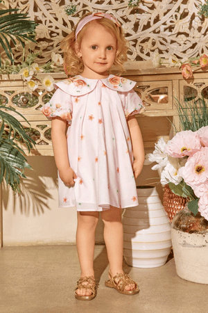 Soft pink dress with scattered floral prints, puff sleeves, and an oversized collar with flower accents