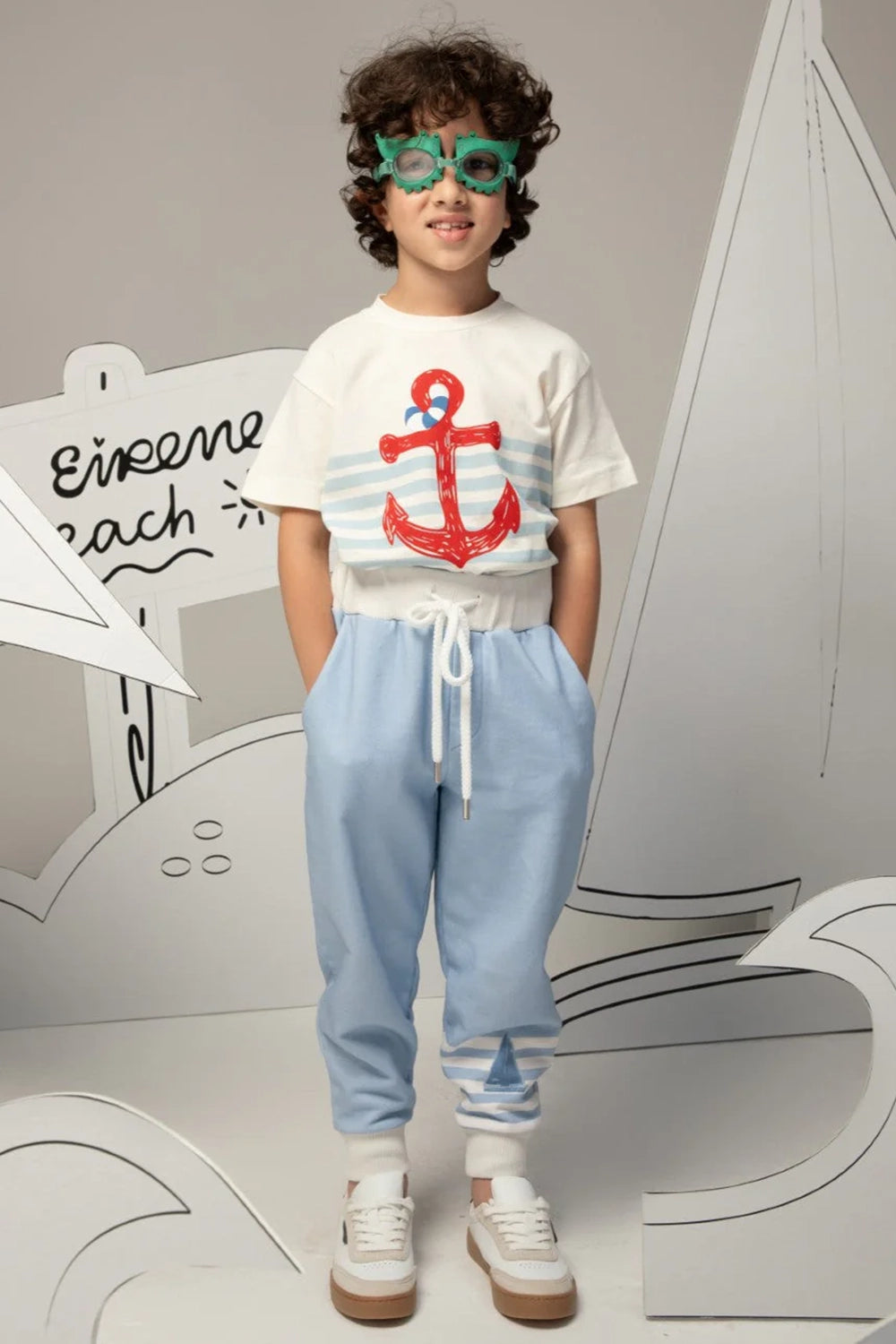 بنطال أزرق فاتح بأساور مخططة باللون الأبيض ونقش صغير لقارب شراعي على الساق