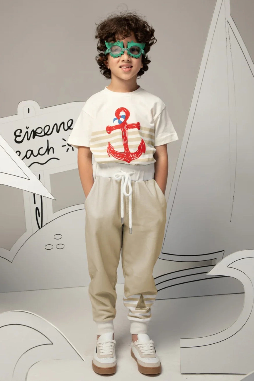 Light blue pants with white striped cuffs and a small sailboat print motif on the leg