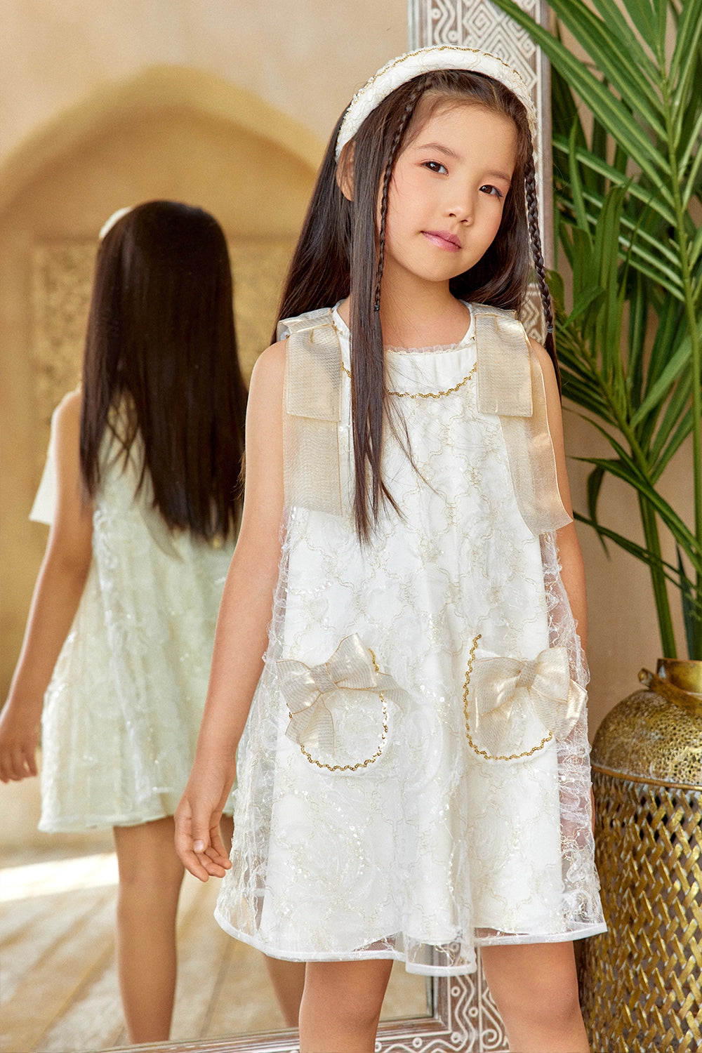 Ivory A-line lace dress with gold shoulder bows and pocket bow details