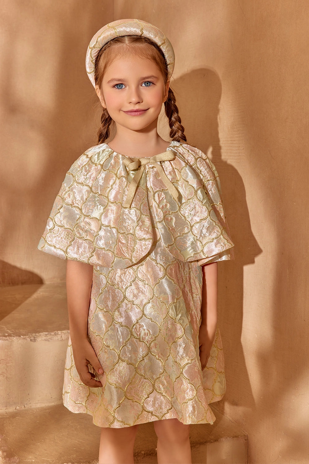 Brocade cape dress with a front bow and soft shine