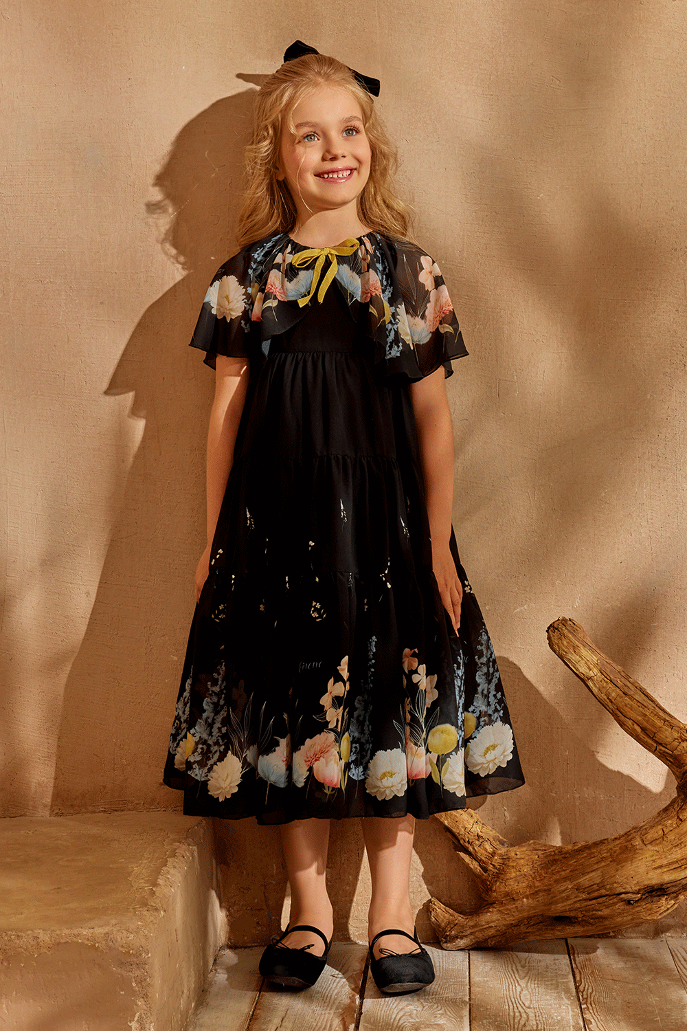 Black chiffon dress with floral cape and yellow bow detail