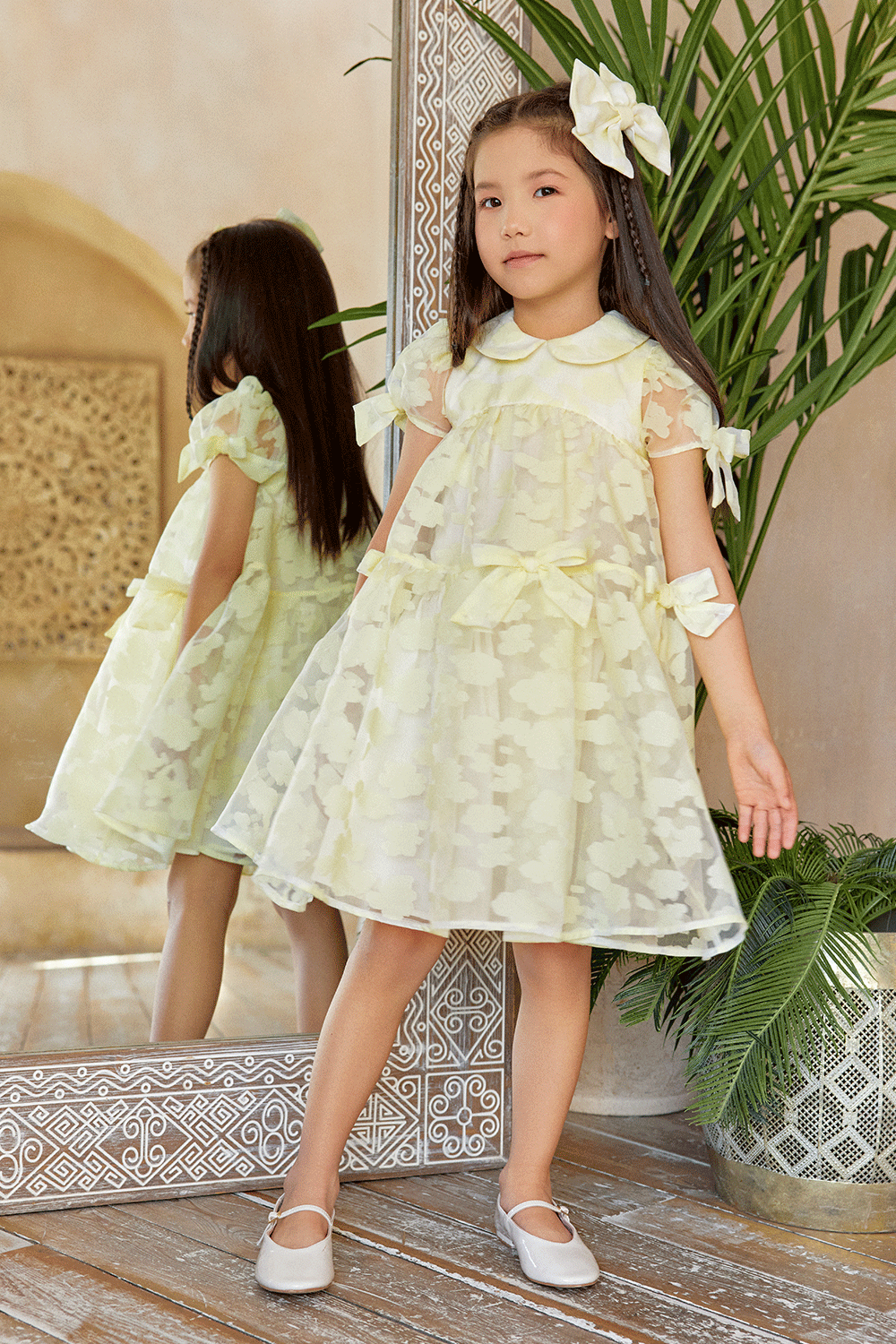 Pale yellow organza dress with texture, puff sleeves, and bows