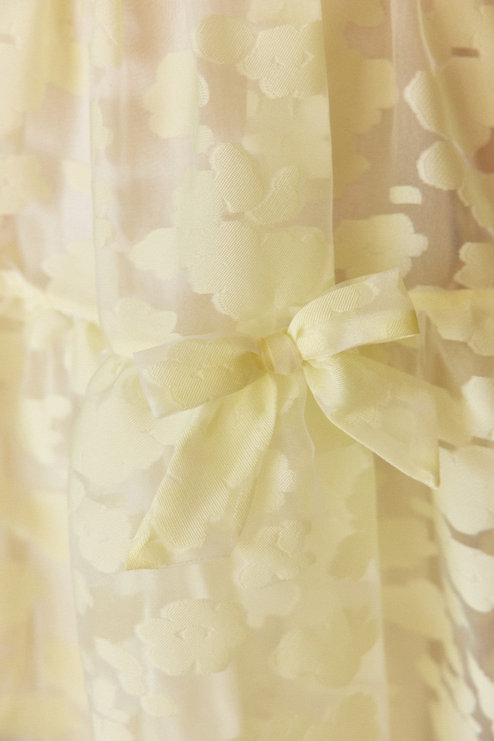 Pale yellow organza dress with texture, puff sleeves, and bows
