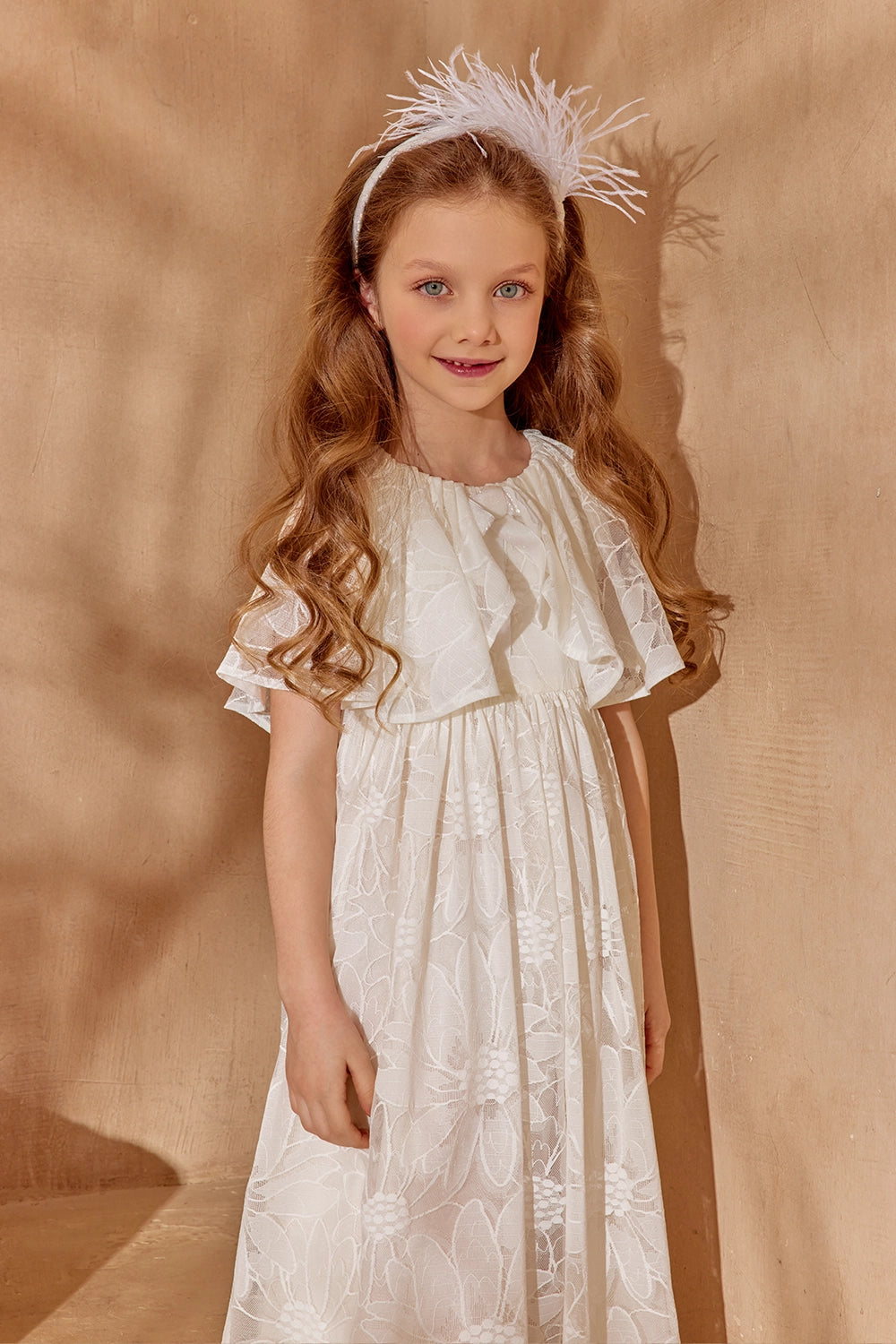 Off-white floral lace dress with flutter sleeves and cape, shimmering bow