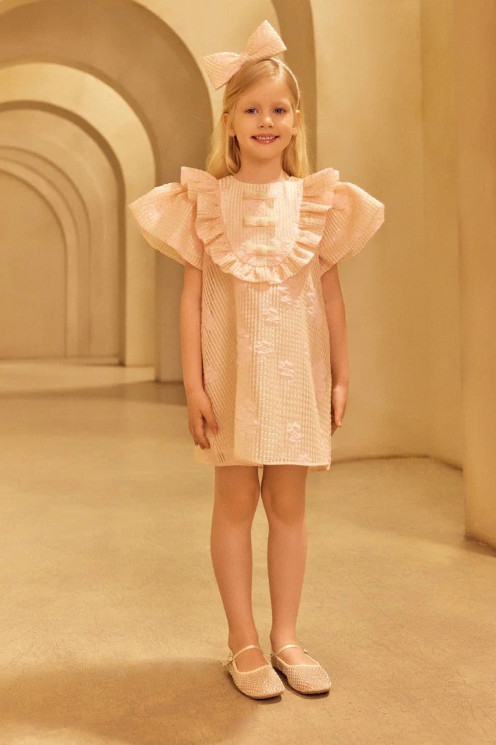 Charming A-line jacquard organza dress in light pink with voluminous ruffled shoulders and front shimmering bows in mint and pink