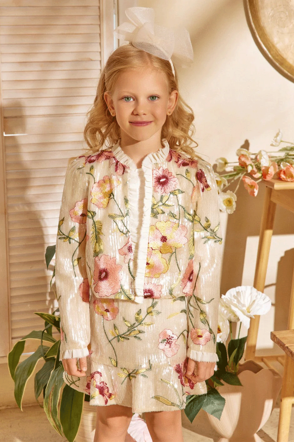 Ivory sequin set featurting a floral embroidered jacket with pleated trim and a matching mini skirt with frill